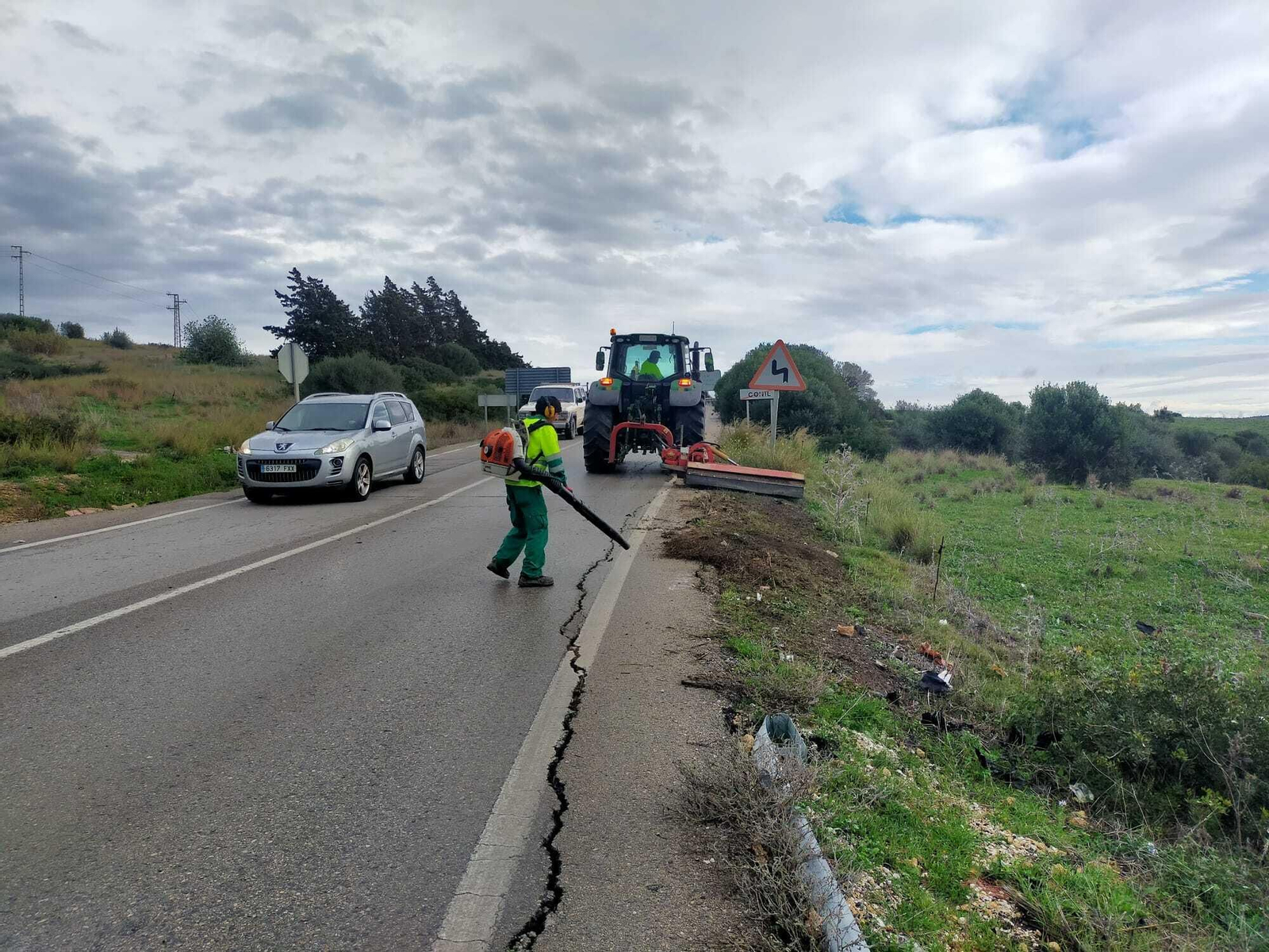 Operarios de la Junta de Andalucía durante el segado de la vegetación una de las carreteras