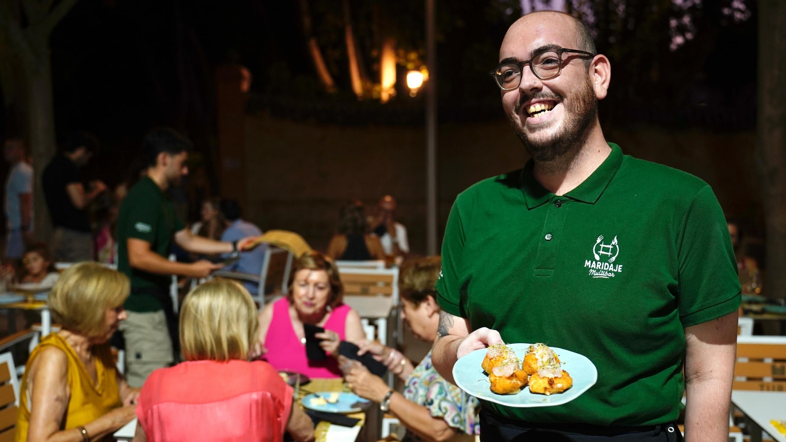 Uno de los camareros del bar Nuevo Maridaje sirve uno de los platos.