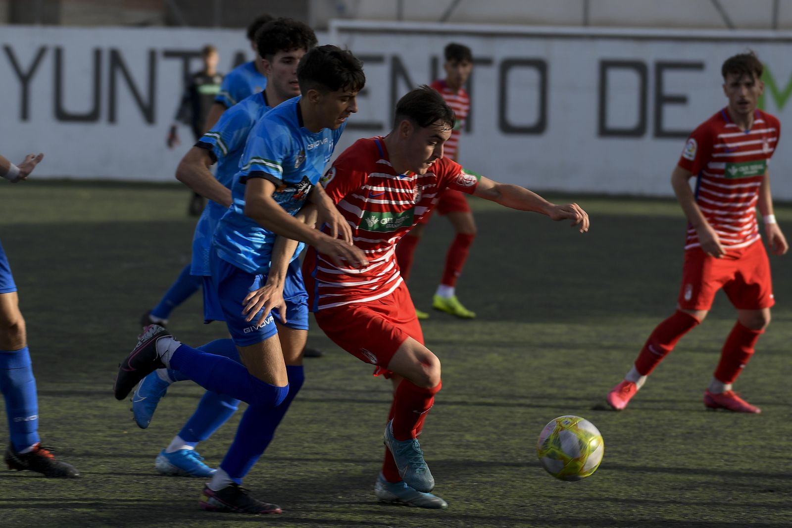 Maracena y Granada CF pugnan por un balón en el centro del campo.