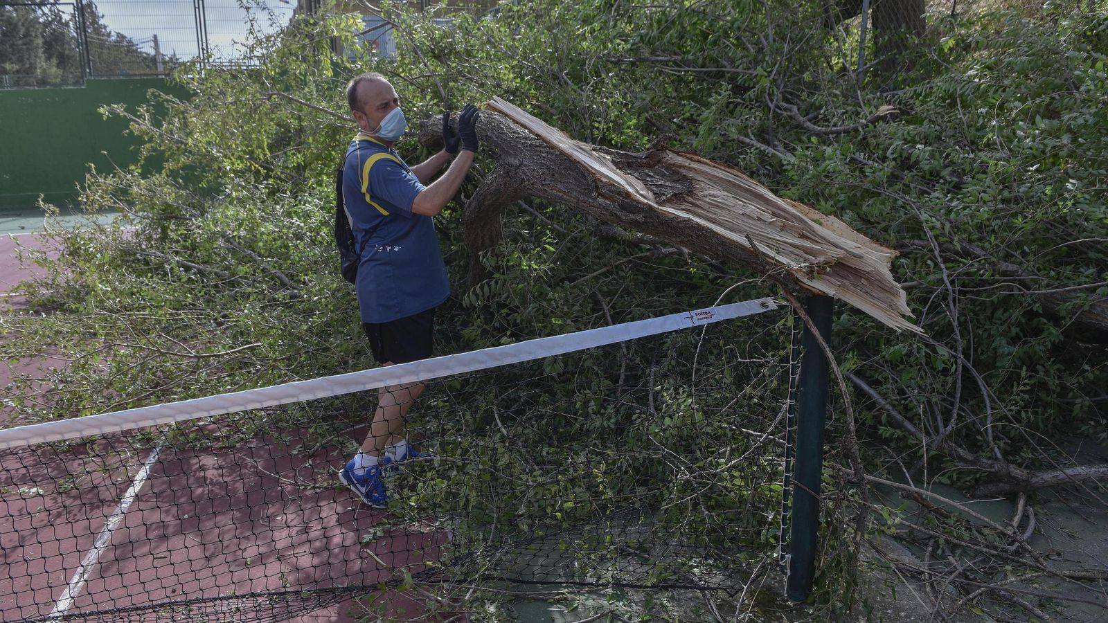 Antonio, operario municipal, retira un árbol de una pista de tenis.