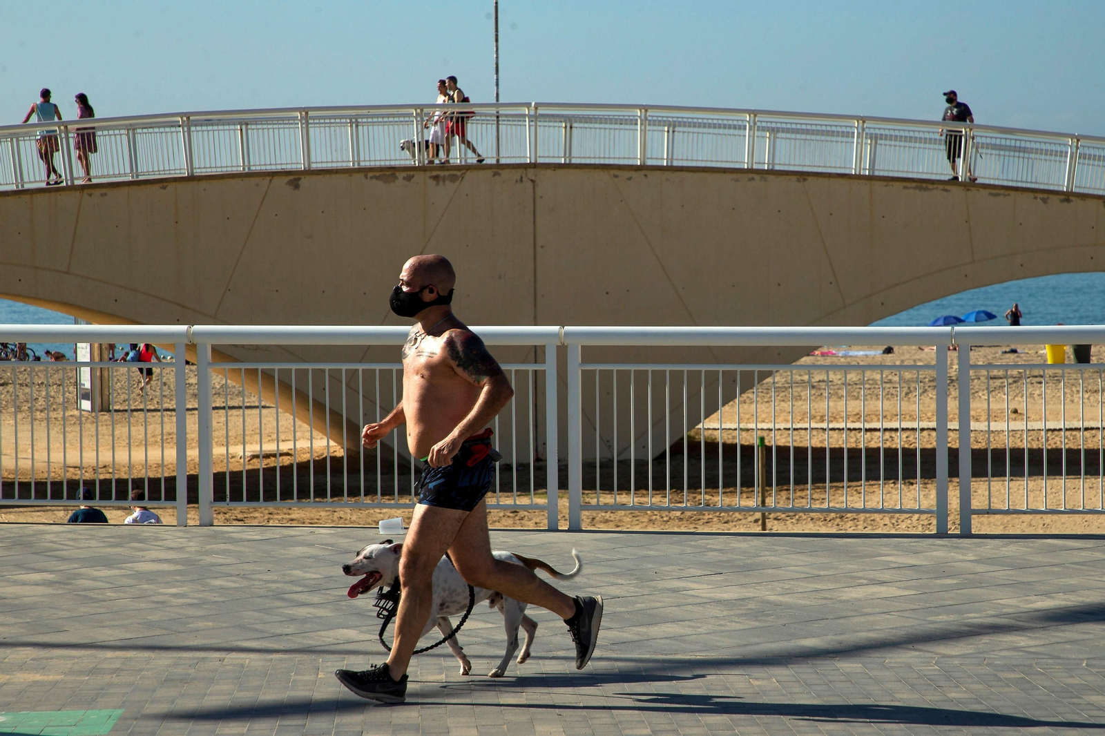 Un hombre hace deporte en Barcelona con mascarilla.