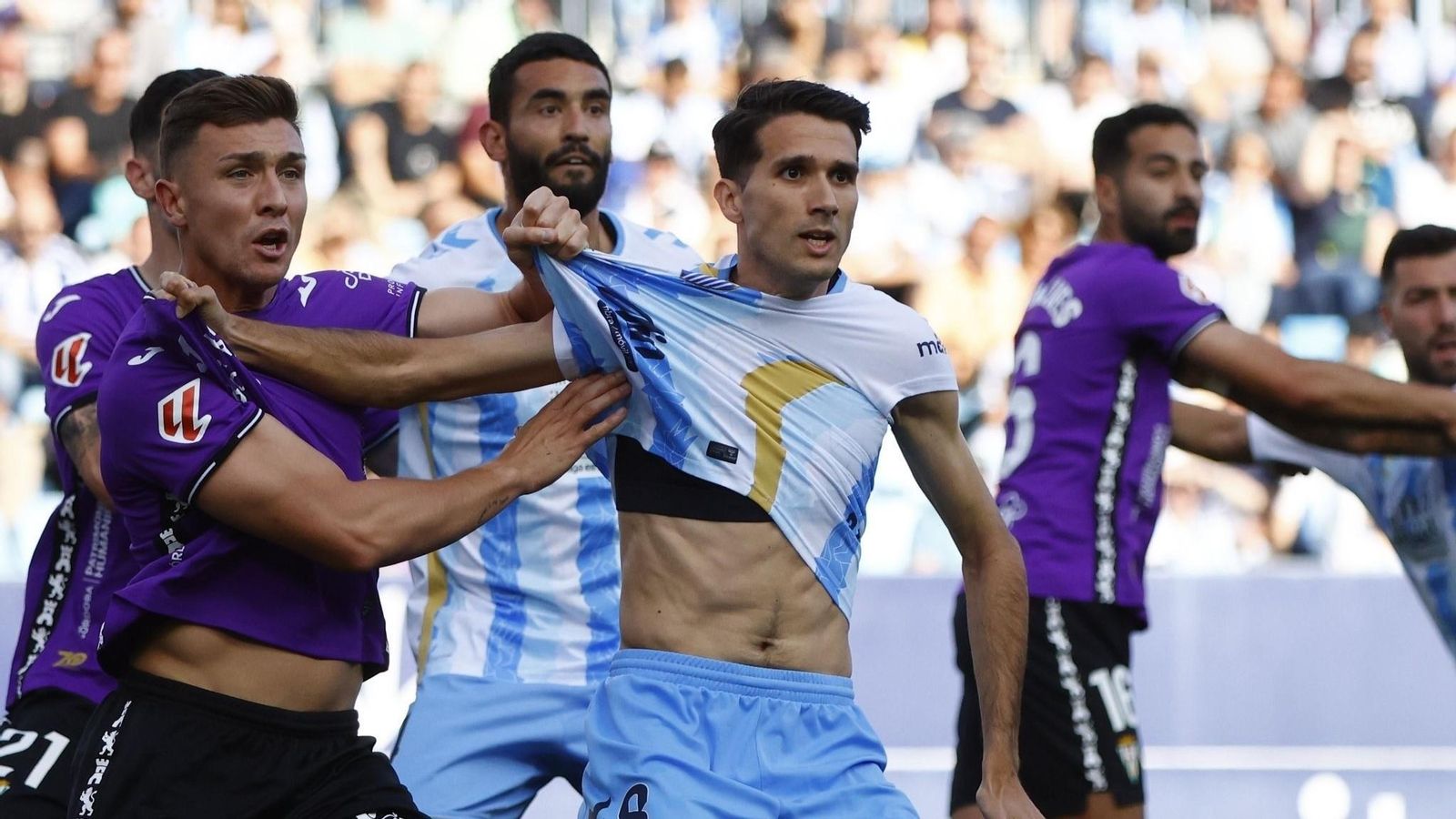 Alberto del Moral pelea por la posición con un contrario en el Málaga - Córdoba CF.