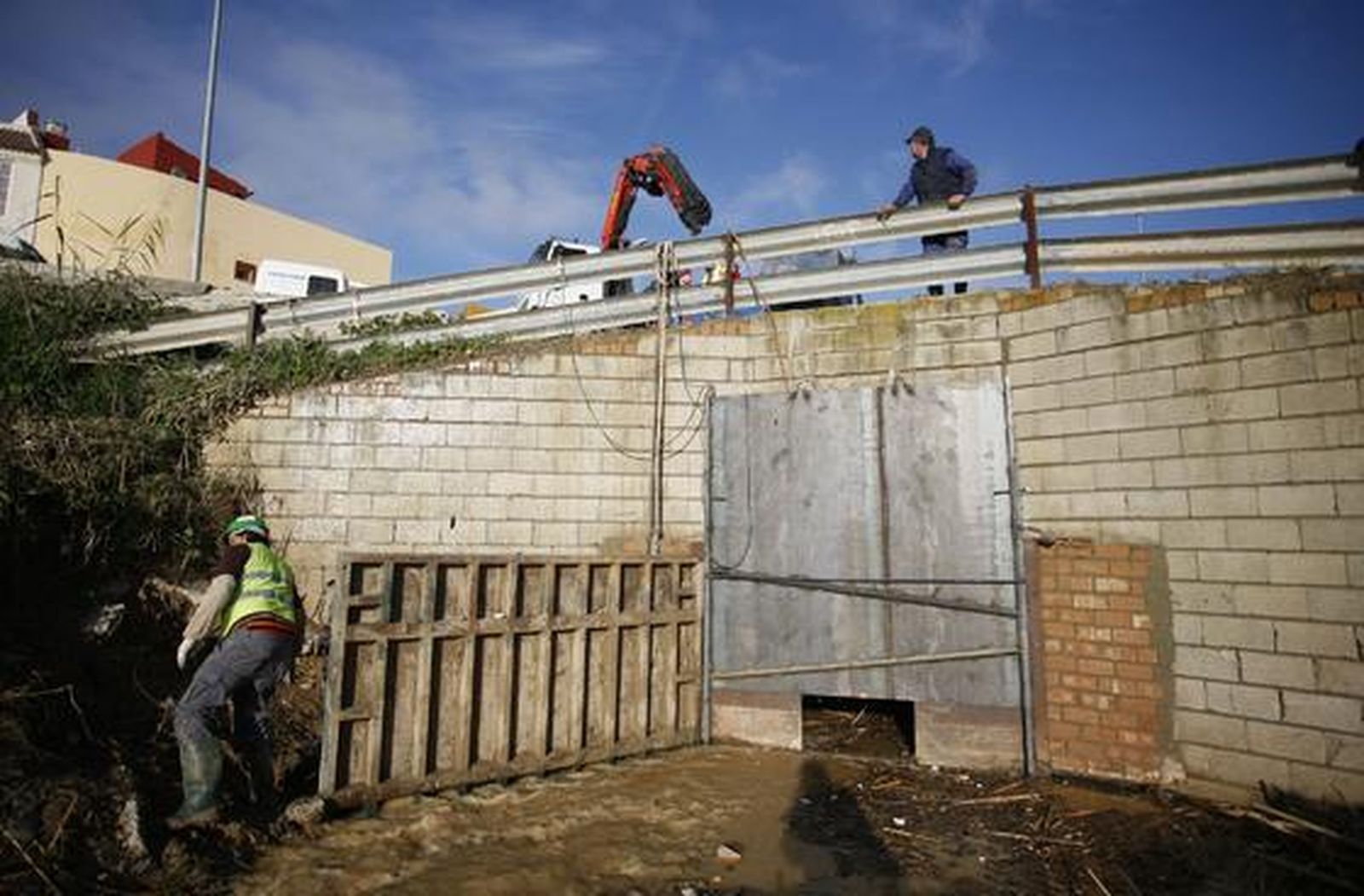 Los trabajadores refuerzan la compuerta para evitar nuevas inundaciones en Écija ante la previsión de lluvias.

Foto: Antonio Pizarro