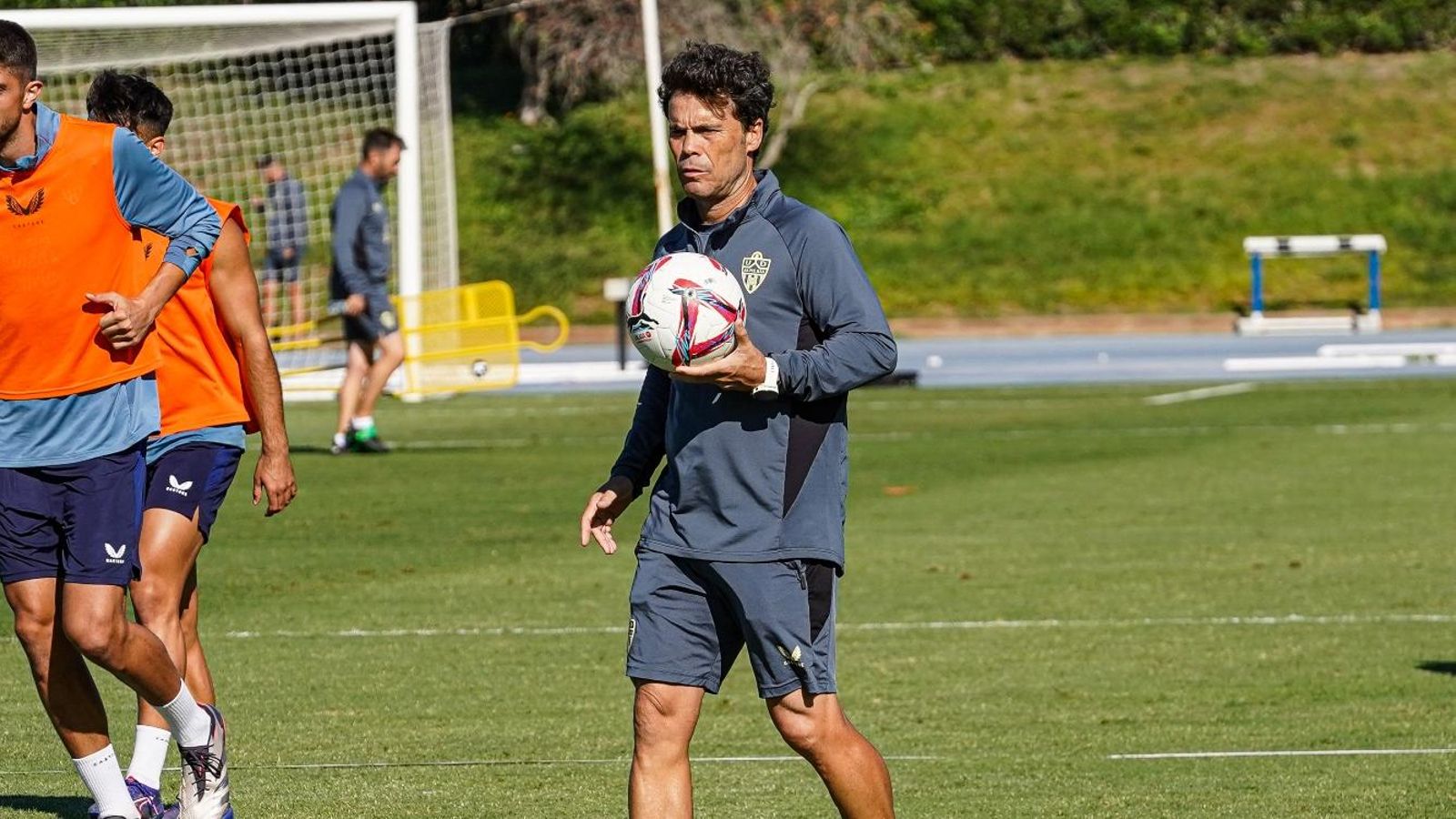 El técnico de Vilassar de Mar, reflexivo con un balón en sus manos.