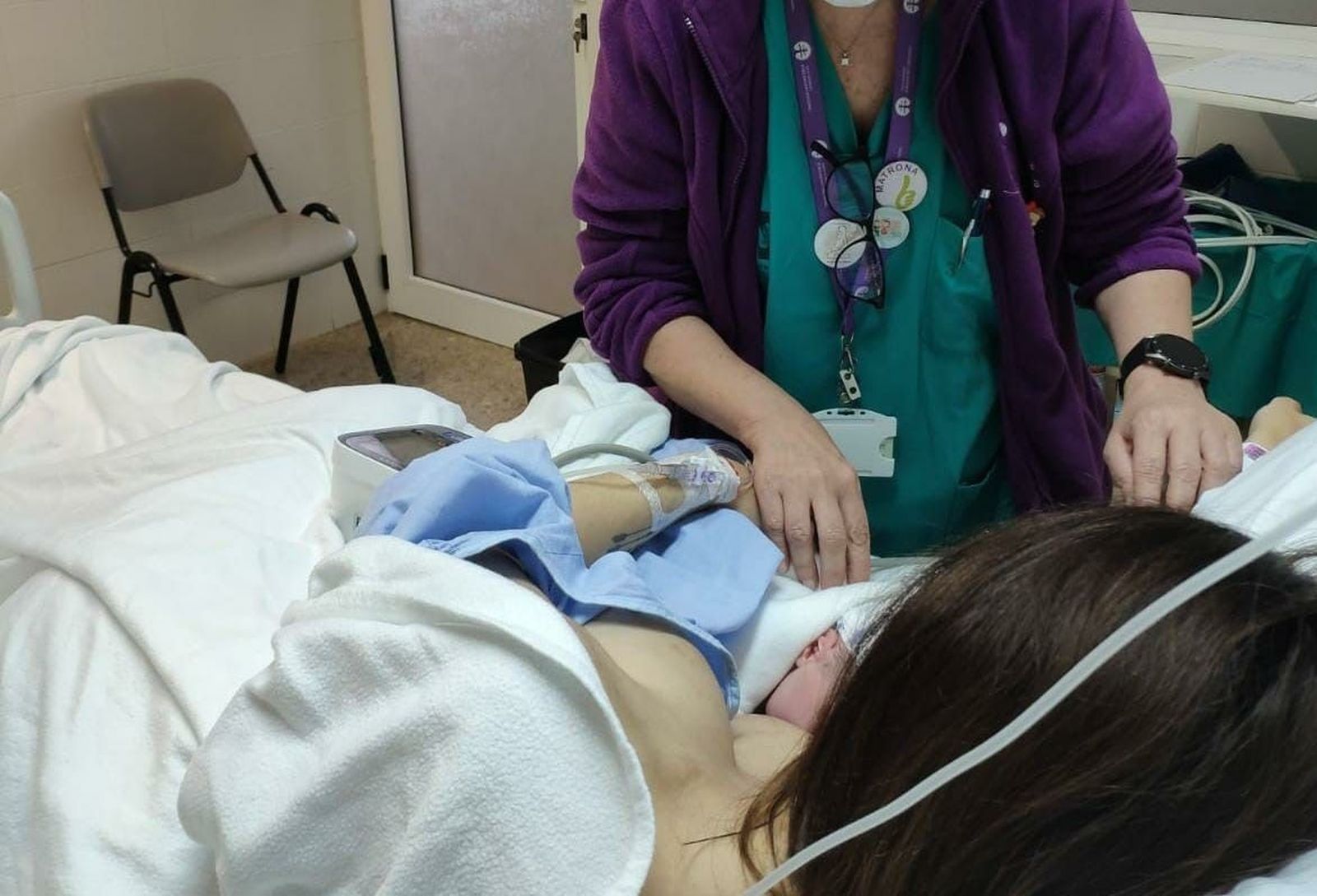 Una matrona atiende a una mujer y a su recién nacido.