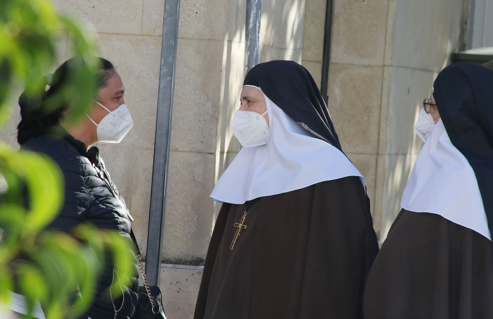 Varias personas, dialogando con mascarillas.