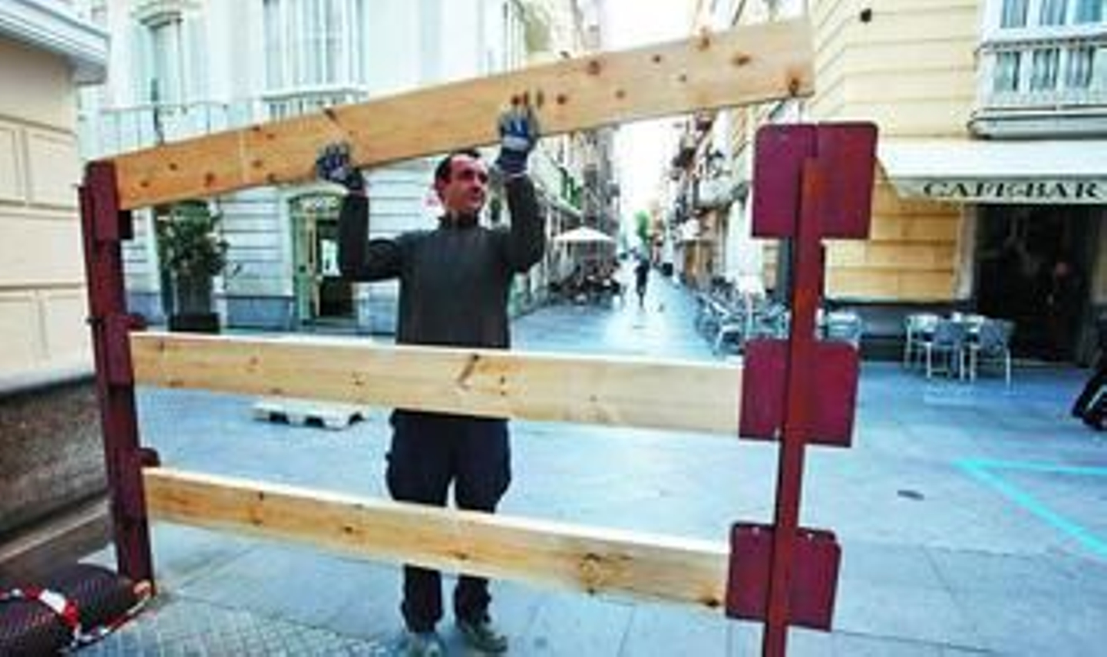 Los preparativos continúan también en el casco histórico de Cádiz, donde un hombre coloca una barrera en la confluencia de Ancha con San José.