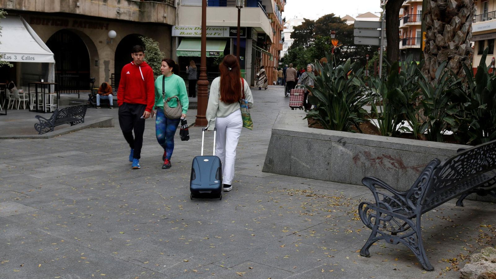 Una joven recorre la ciudad con su maleta.