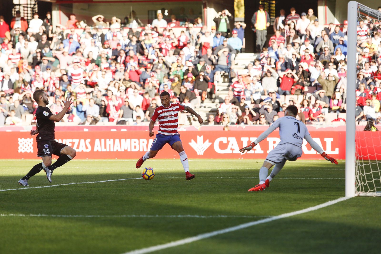 Kunde vigila el bote del balón para controlarlo en presencia del colombiano del Huesca Cucho Hernández.