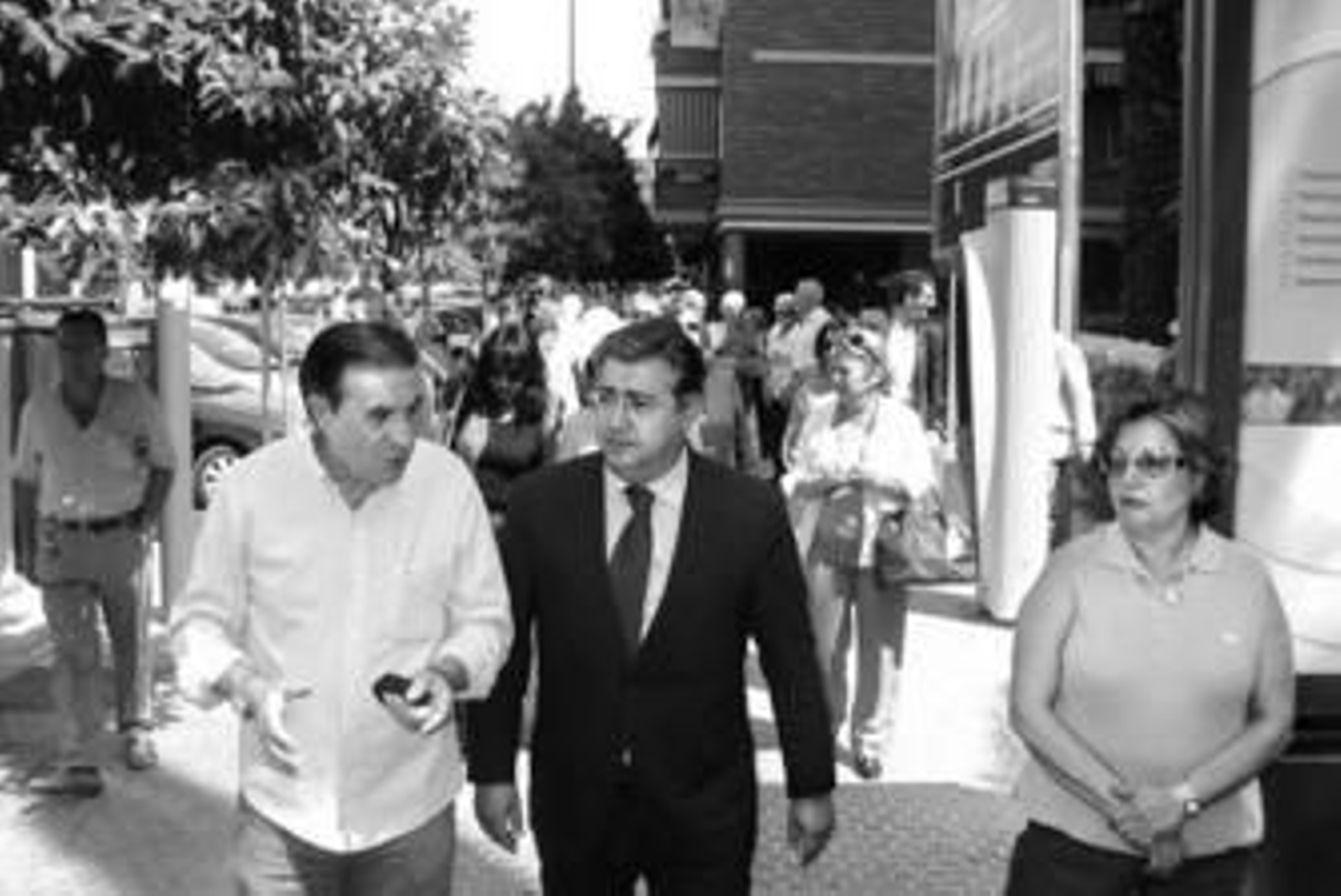 Juan Ignacio Zoido y vecinos de Bami pasan junto al cartel del aparcamiento de la plaza Rafael Salgado.