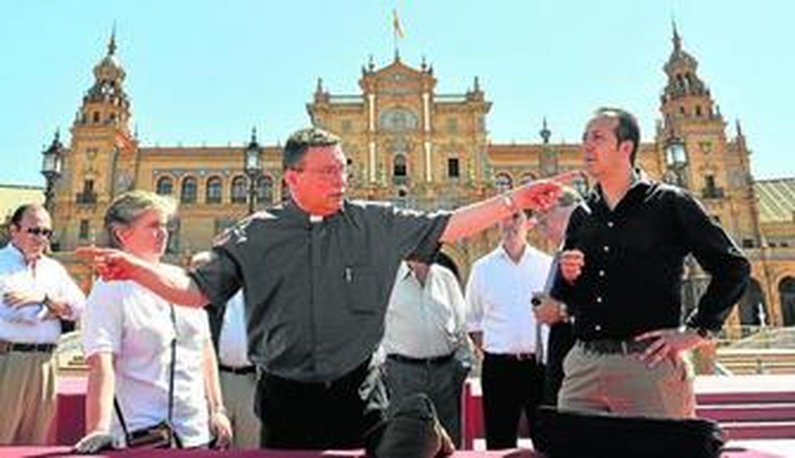 El canónigo Luis Rueda, junto a otras personas que participarán en la ceremonia, ayer en la Plaza de España, organizando la ceremonia.
