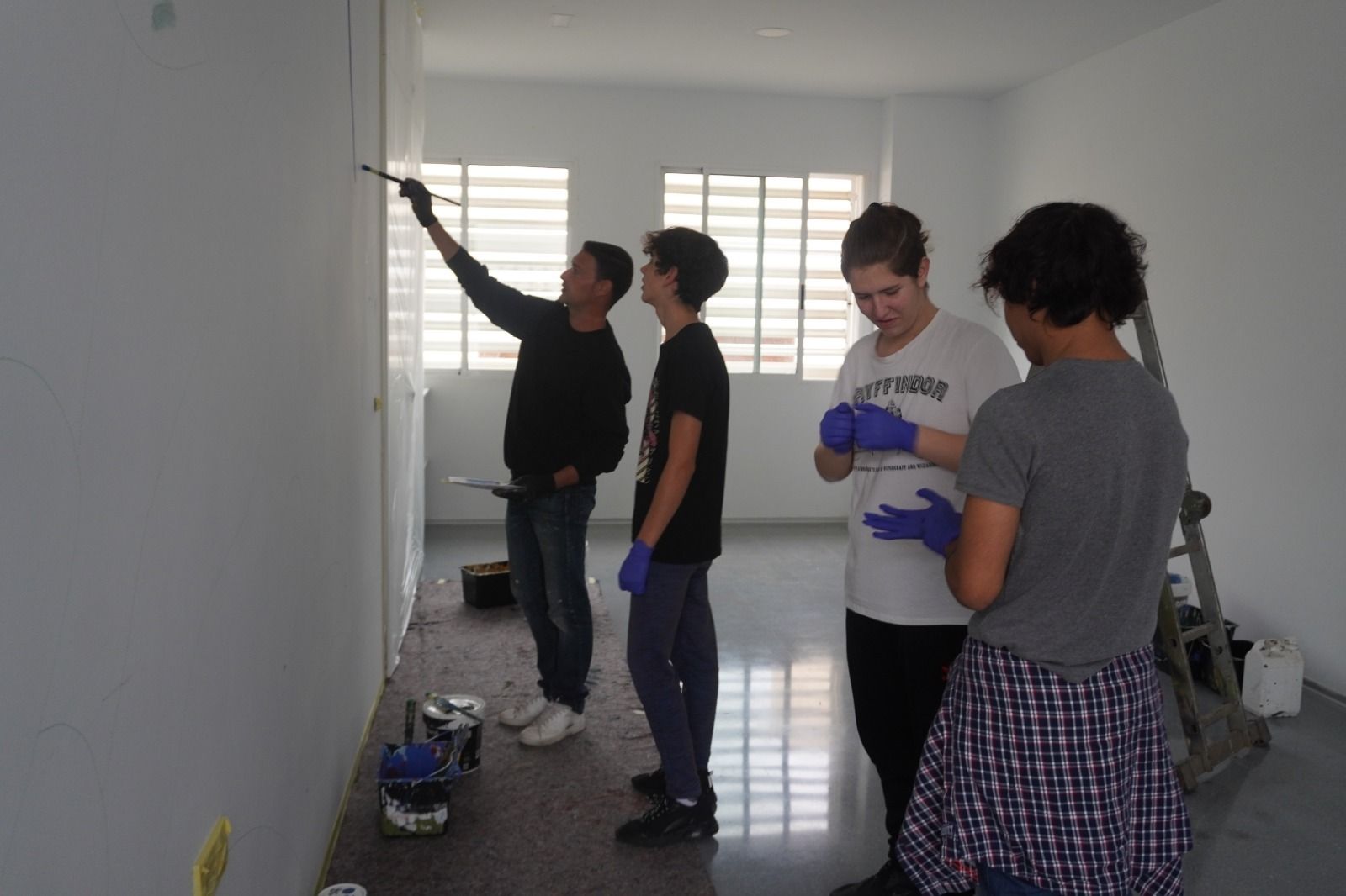 Jóvenes pintando un mural en el nuevo espacio para ellos.