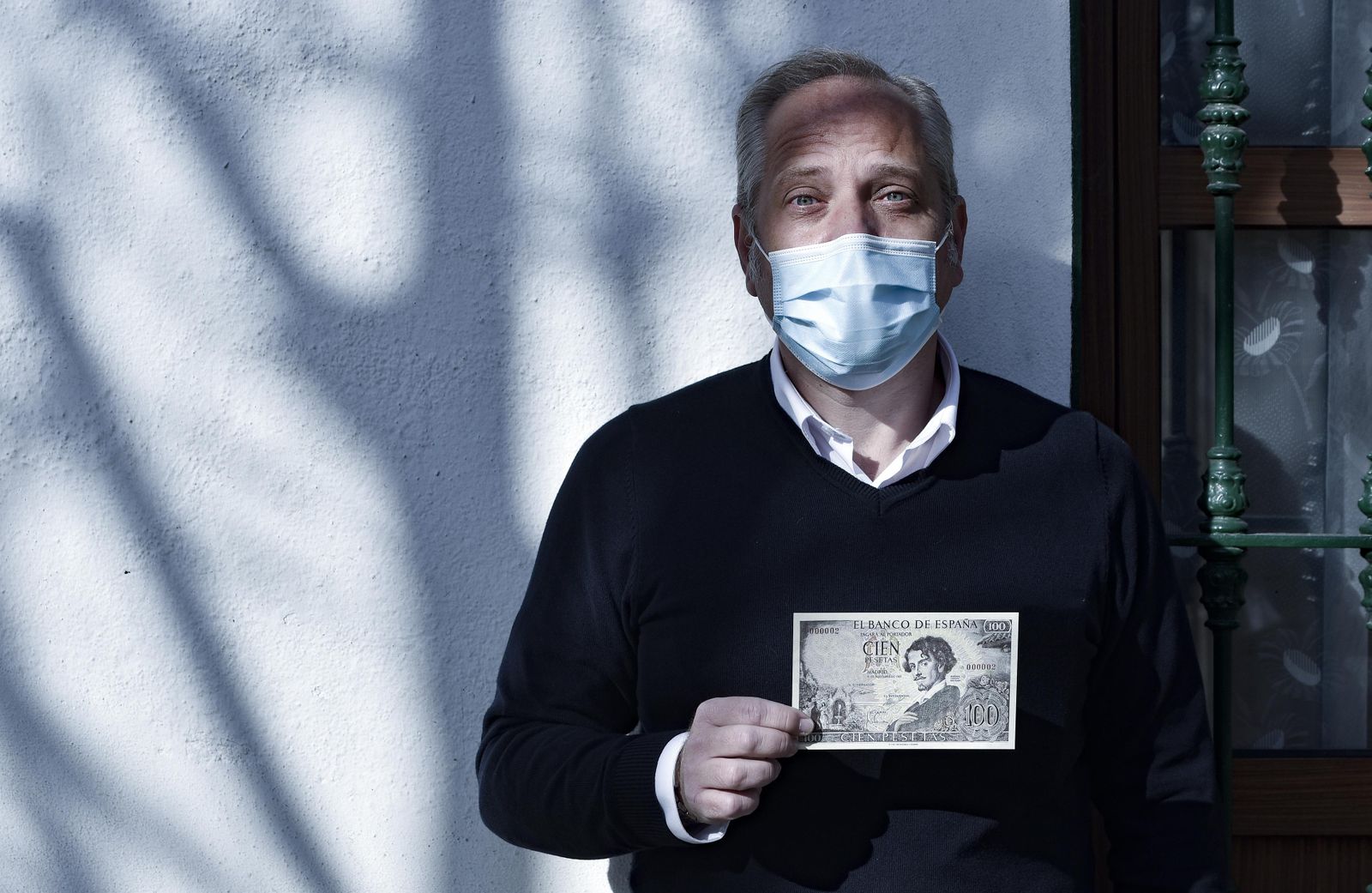 Javier Castro, coordinador del monográfico sobre Bécquer, con el billete de 100 pesetas que hace las veces de invitación.