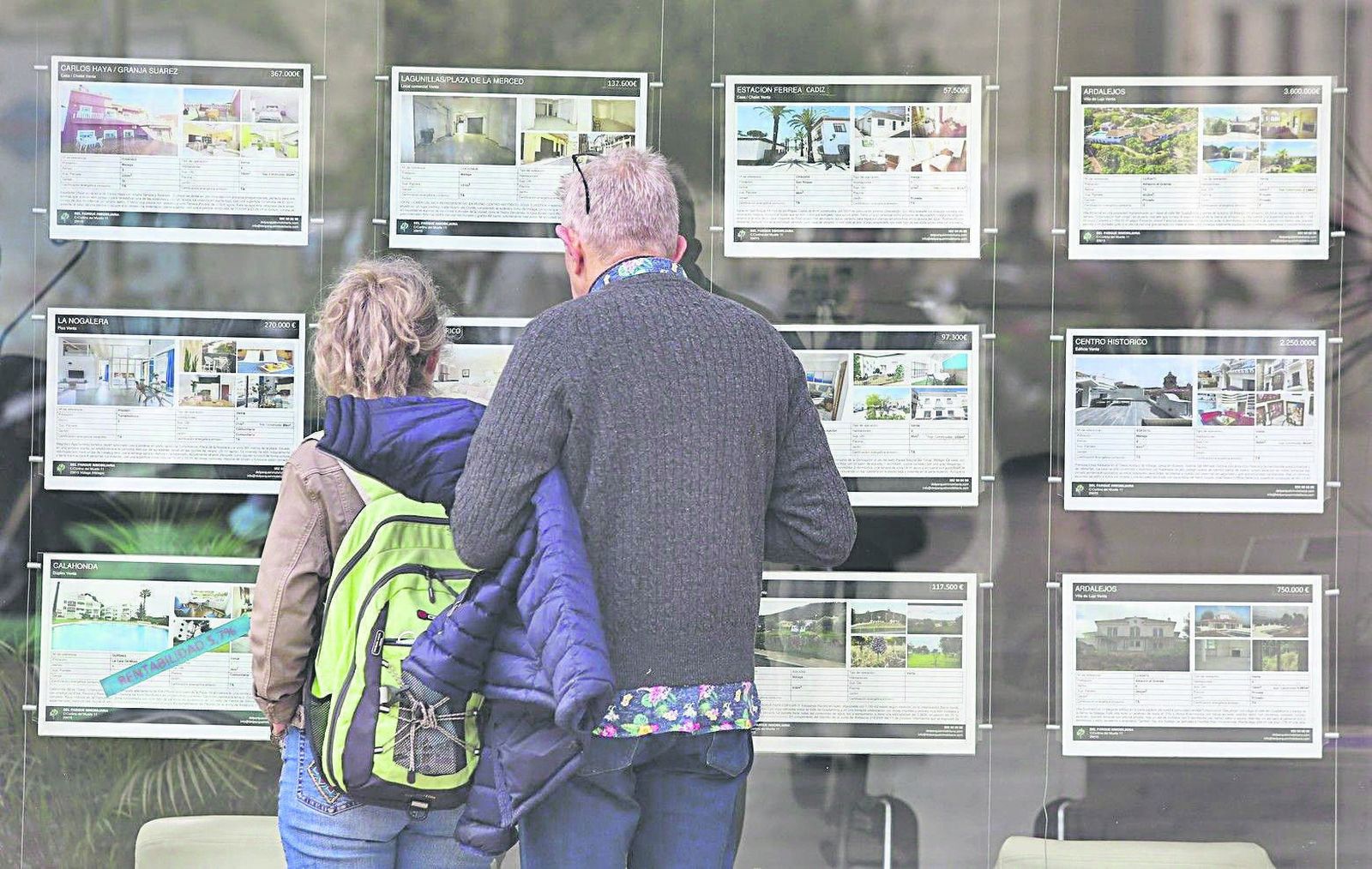 Dos personas se paran junto a ‘escaparate’ dehipotecas para echar un vistazo a las más interesantes.