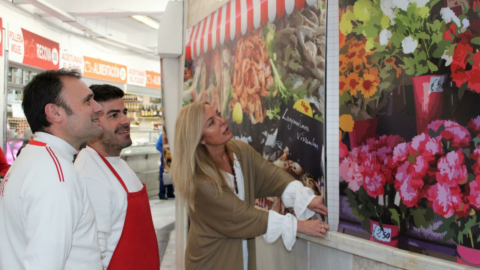 La concejala de Comercio, Blanca Merino, junto a dos de los placeros mostrandoles los nuevos toldos.