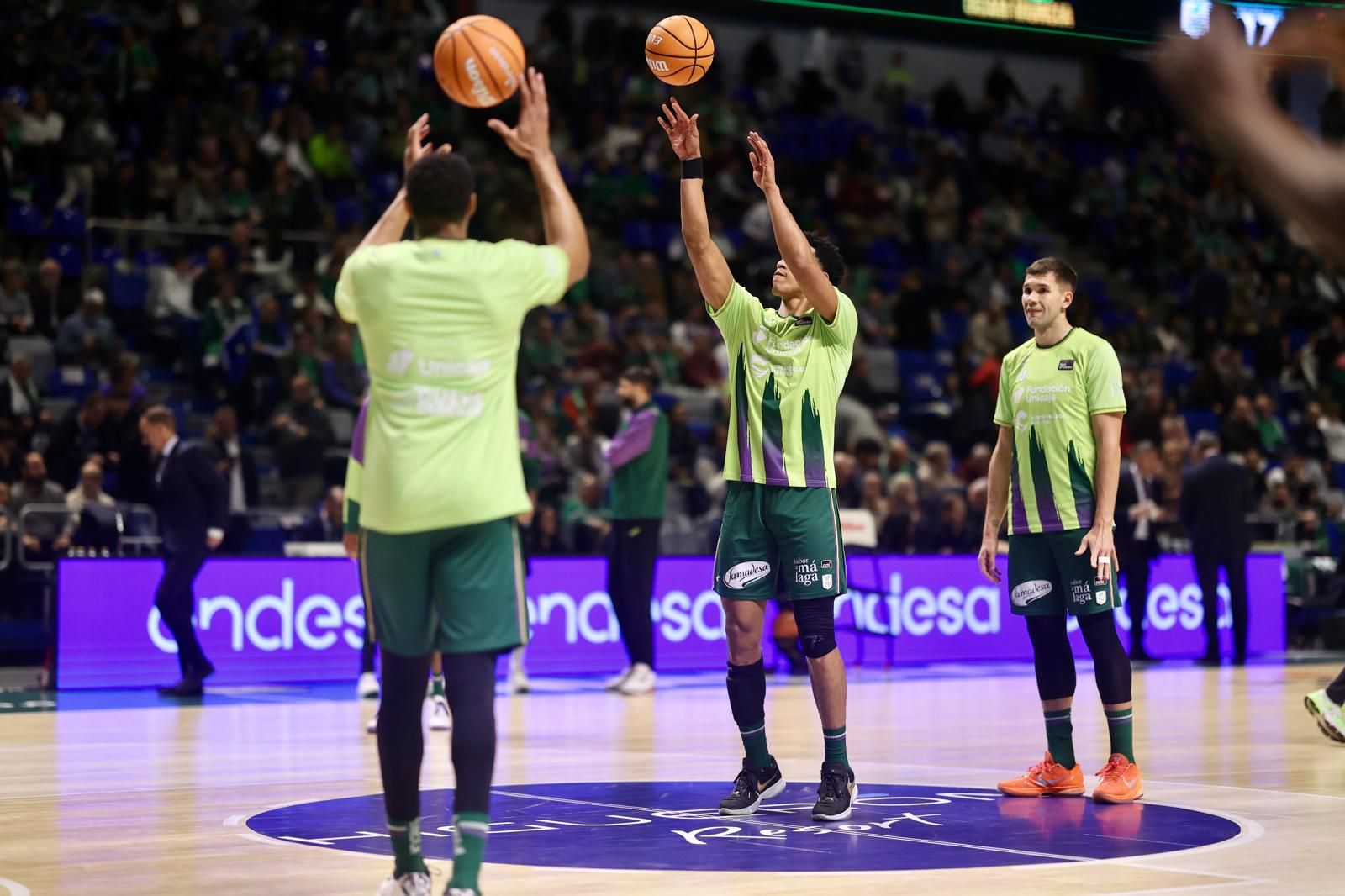 Los jugadores del Unicaja calientan.