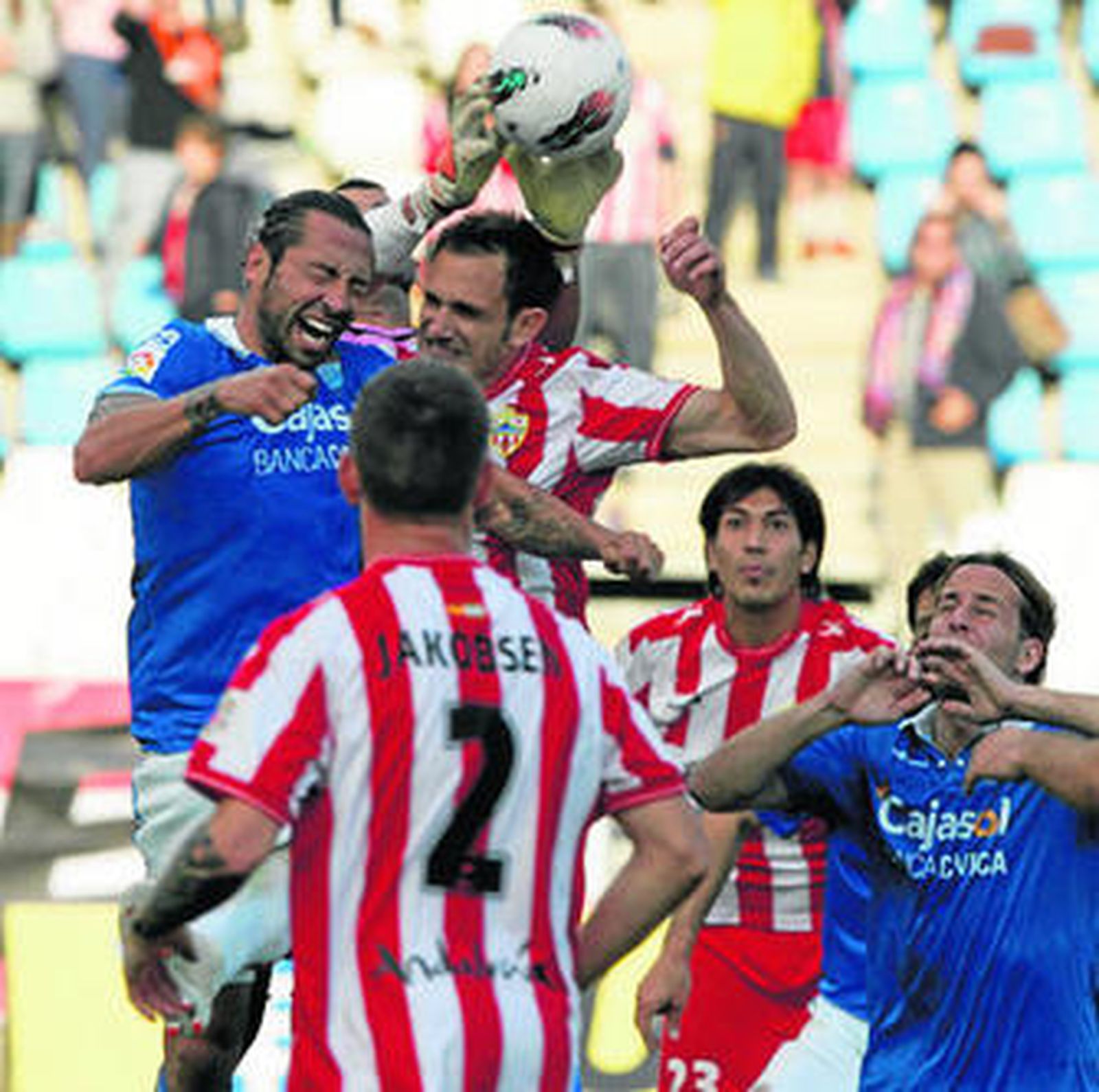 Carlos García salta por un balón junto al ariete xerecista José Mari y el meta Doblas en el duelo del pasado sábado.