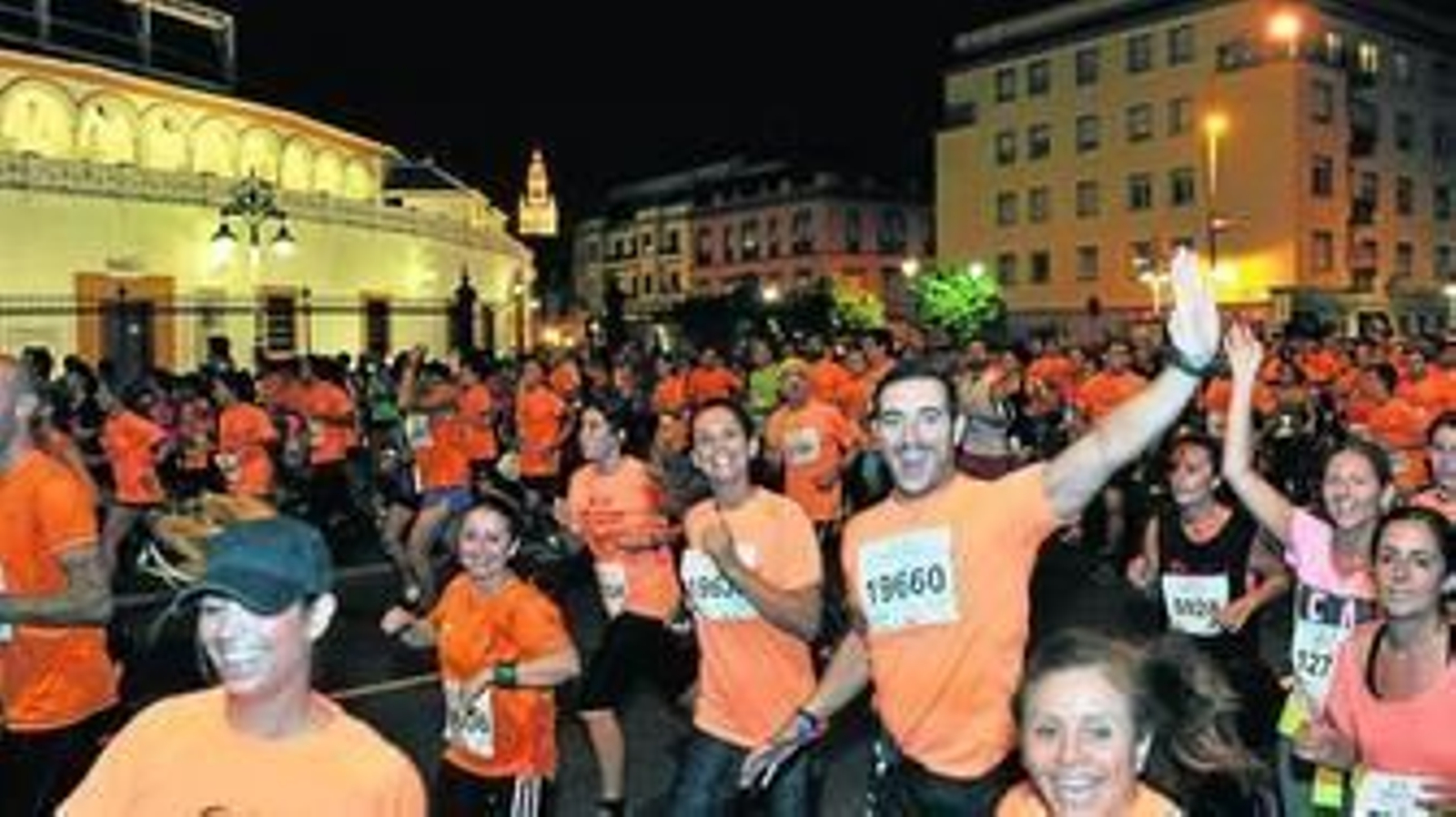 Los corredores a su paso por la Plaza de Toros de la Maestranza, con la Giralda al fondo.