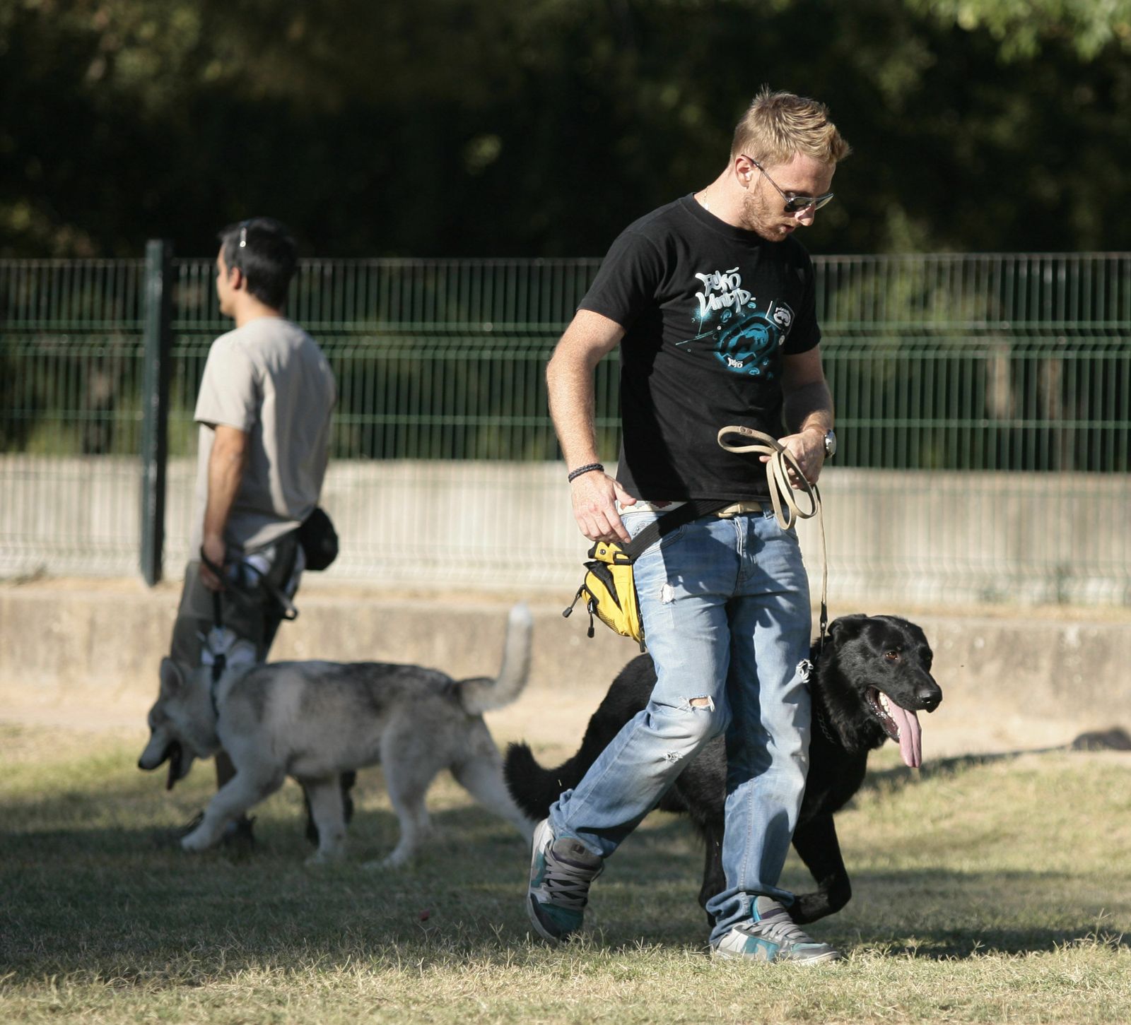 Dos personas pasean a sus mascotas en una foto de archivo.