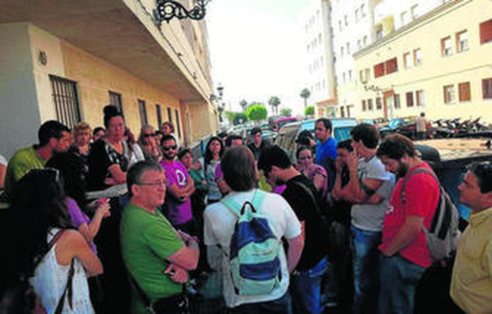 Mari Carmen Pinedo, a la izquierda, arropado por unos ciudadanos ante el edificio donde ocupa una casa.