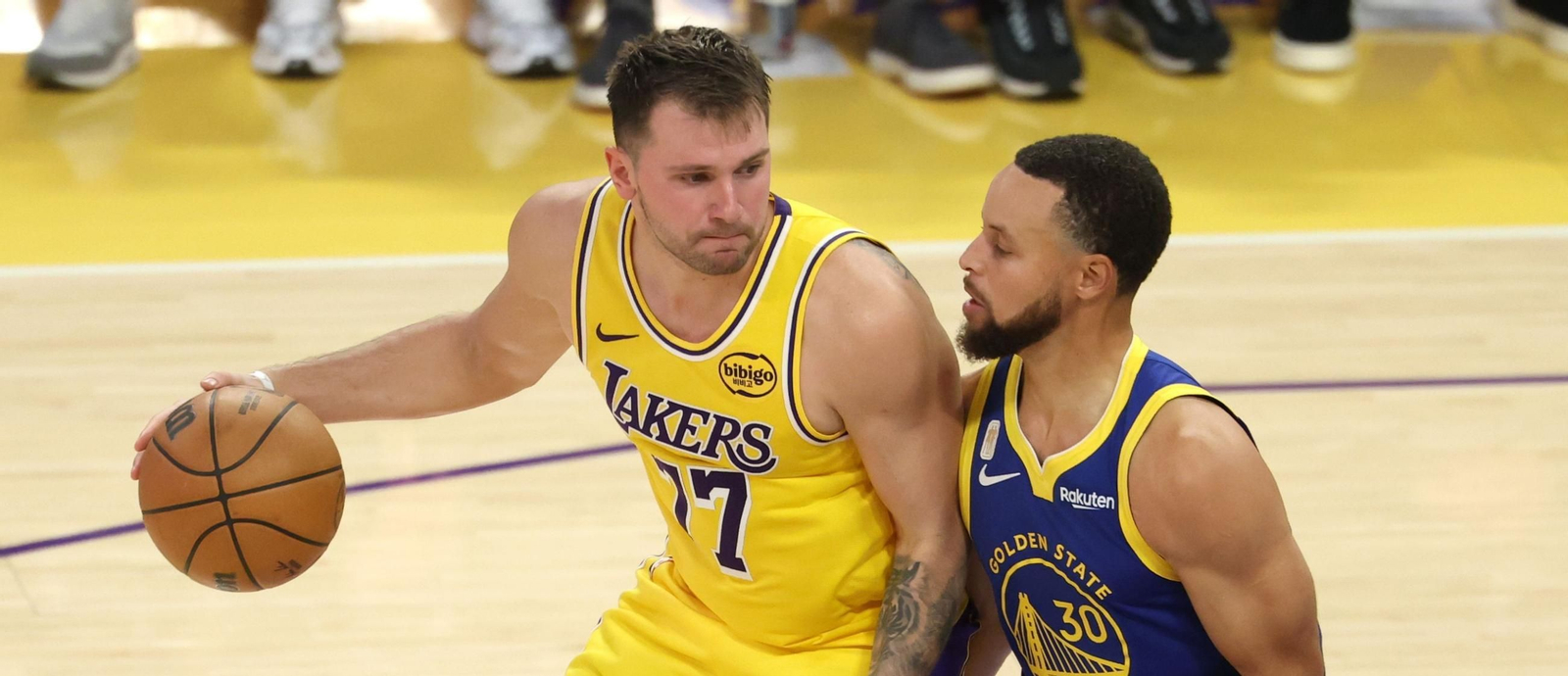 Luka Doncic bota el balón ante la pegajosa defensa de Curry.