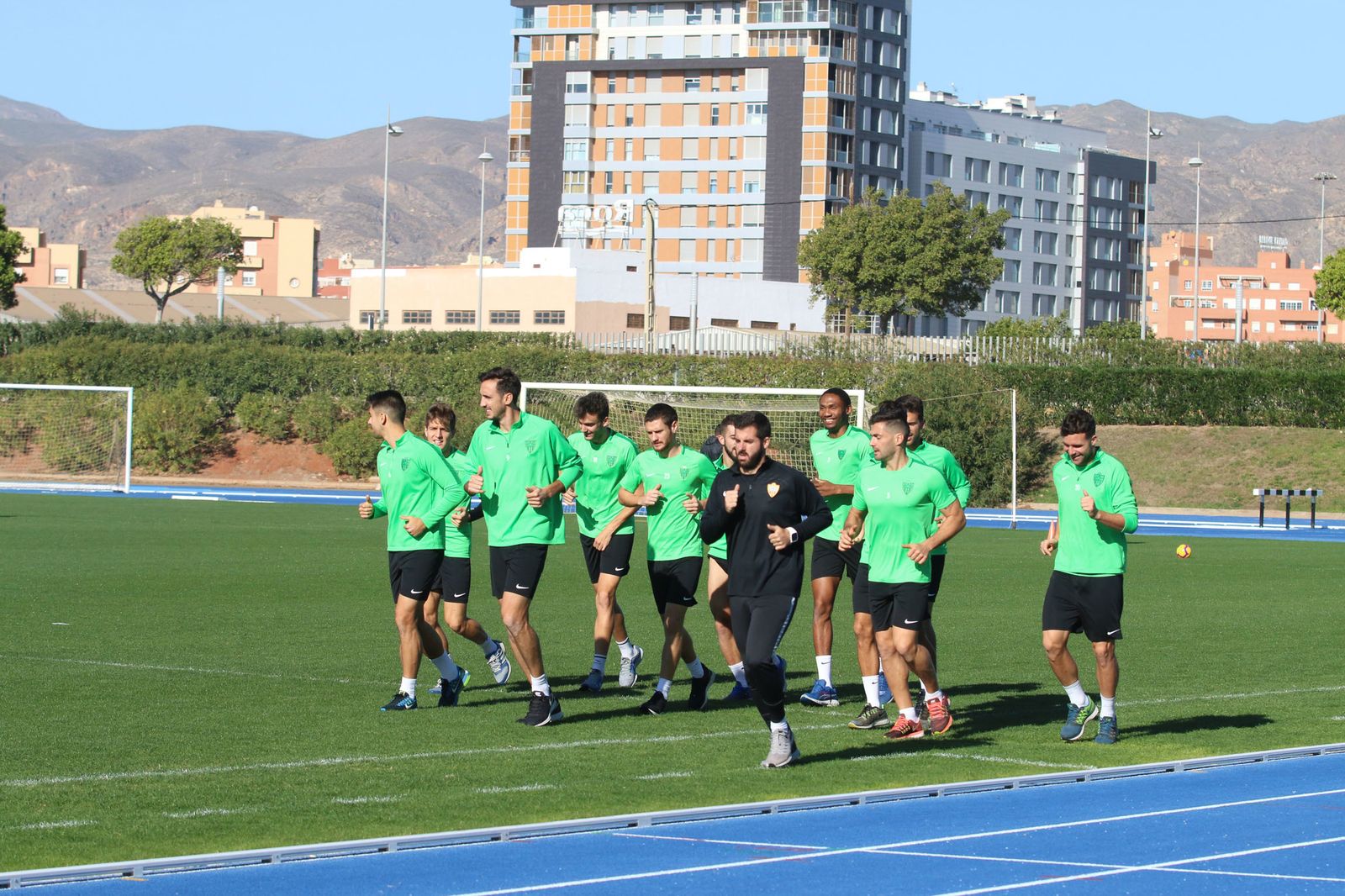 Los jugadores realizan carrera continua junto al preparador físico en el anexo