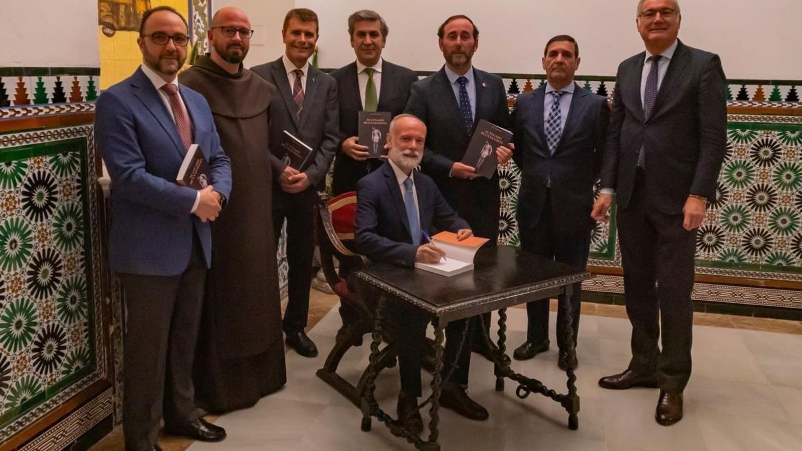 Fernando Mósig firmando ejemplares de 'El legado de un genovés', junto a los miembros de la junta de gobierno de la cofradía del Santo Entierro y el padre David Alarcón.