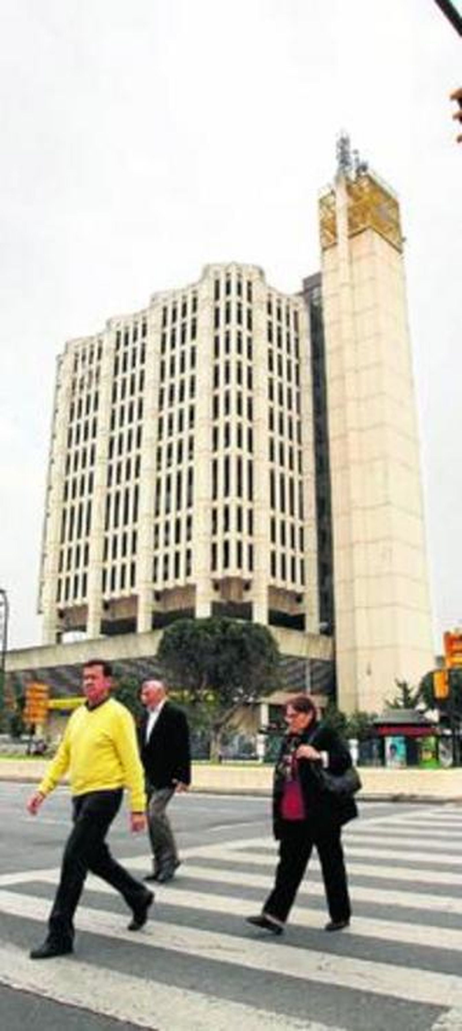 Varios peatones pasan junto al edificio de Correos.
