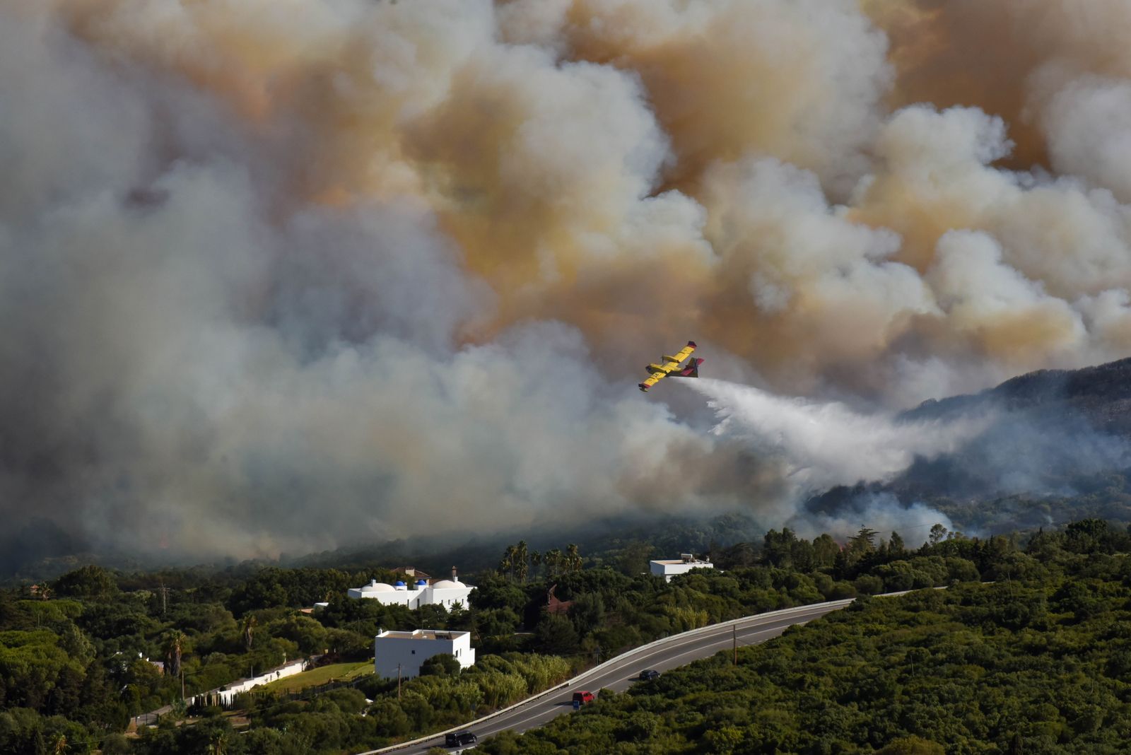 Un avión del Infoca, intentando sofocar el incendio declarado este lunes en el término municipal de Tarifa.