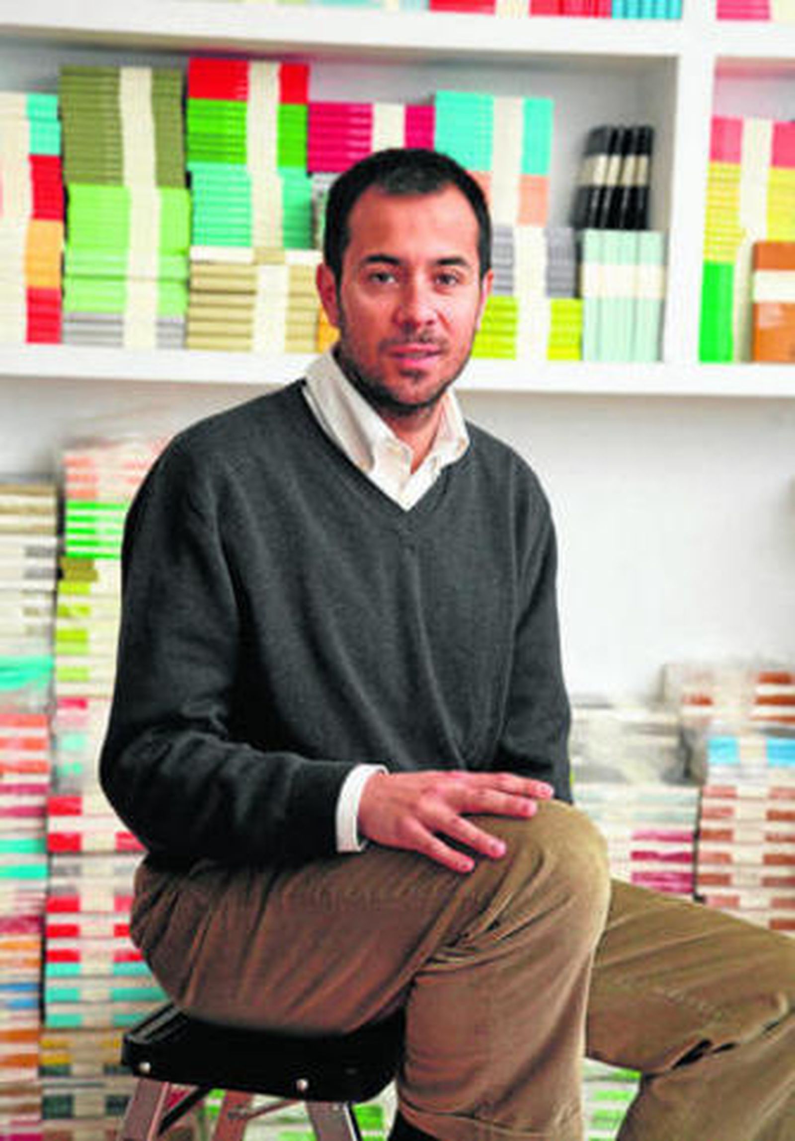 El editor Luis Solano, rodeado de títulos de Libros del Asteroide.