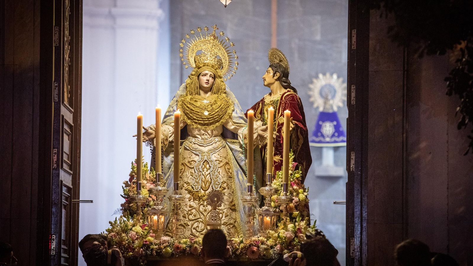 La Virgen de la Luz y San Juan Evangelista pasan por el dintel de la puerta.