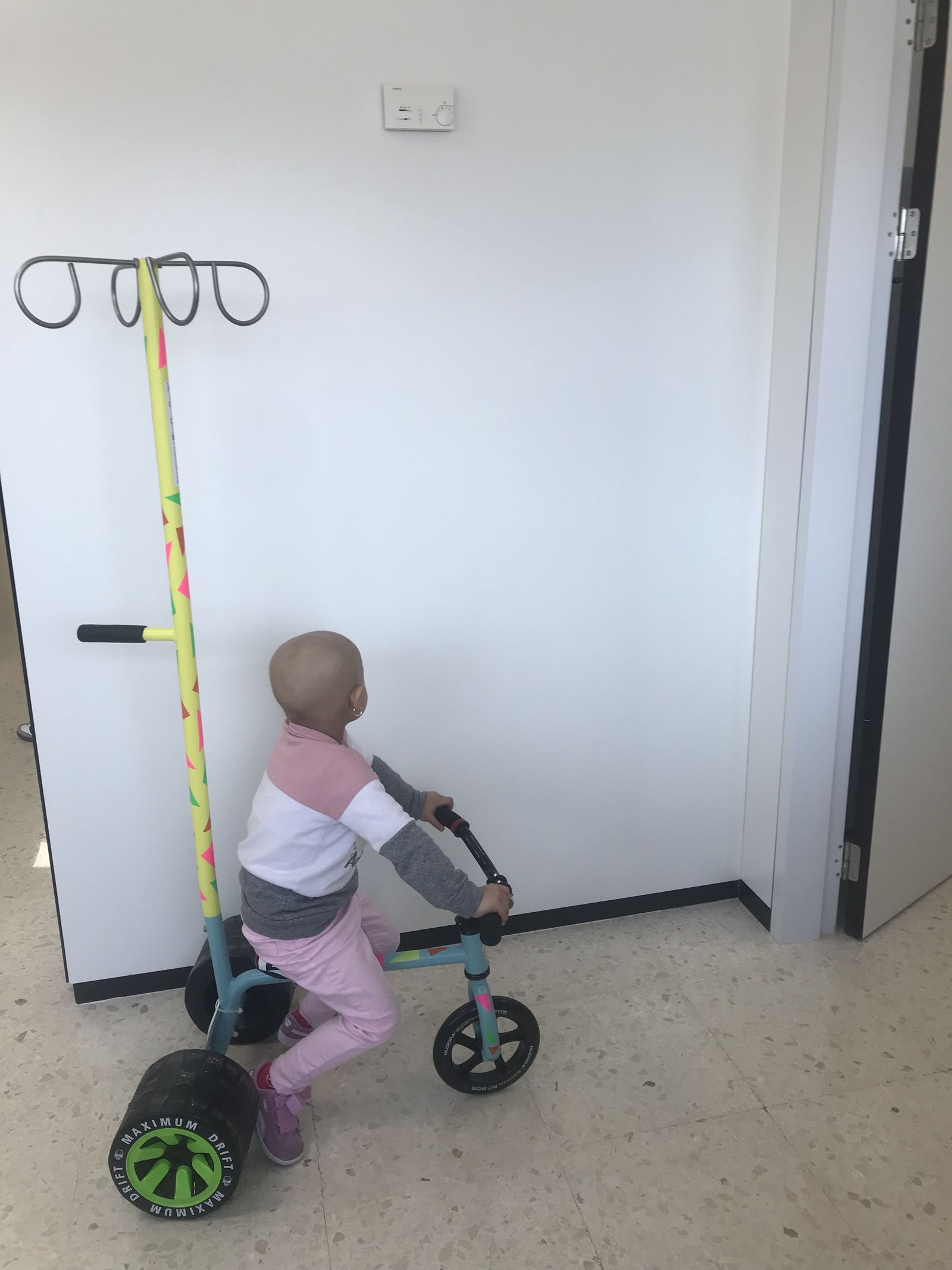 Una niña juega con el triciclo.