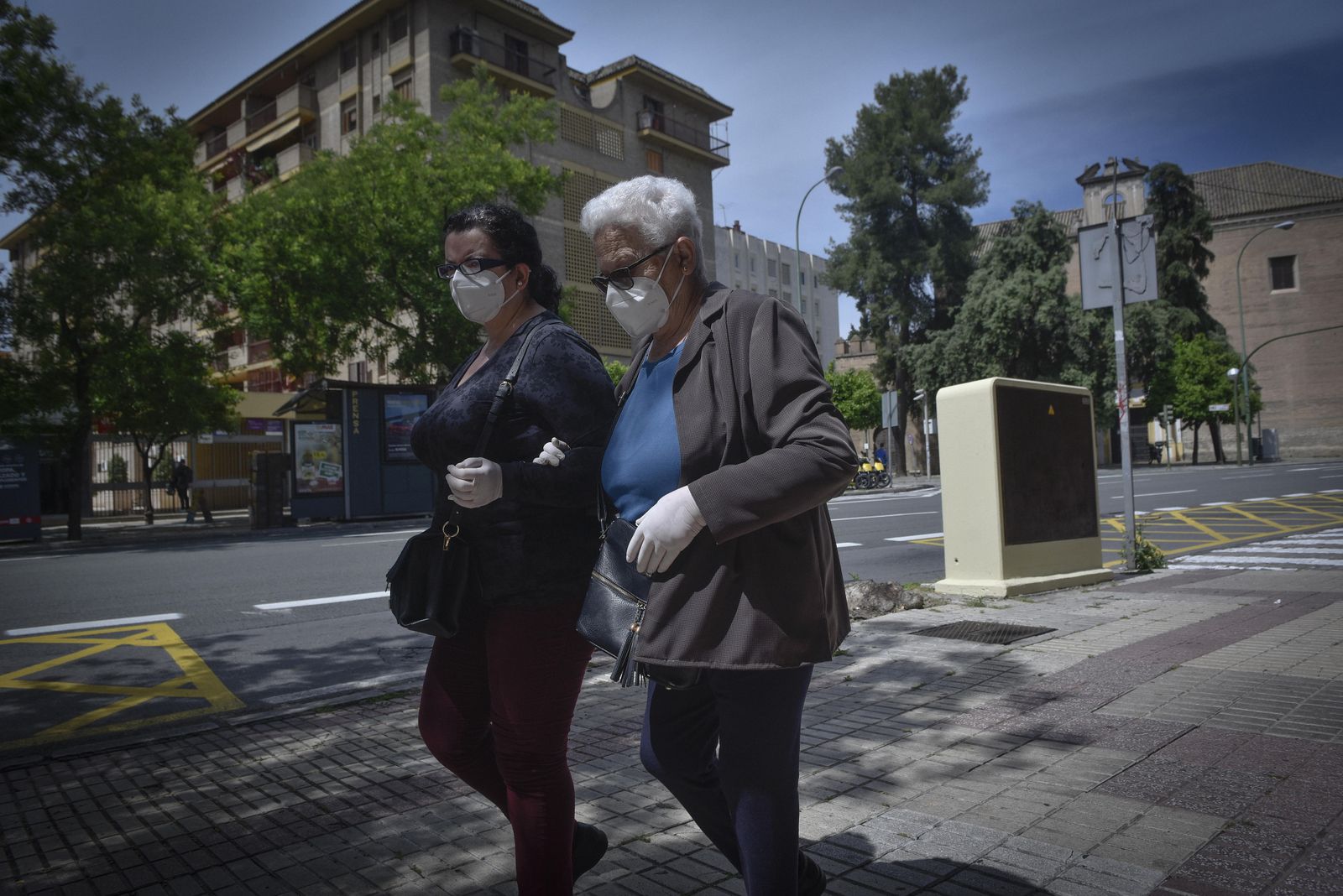 Dos mujeres caminan por la Ronda de Capuchinos protegidas con guantes y mascarillas.