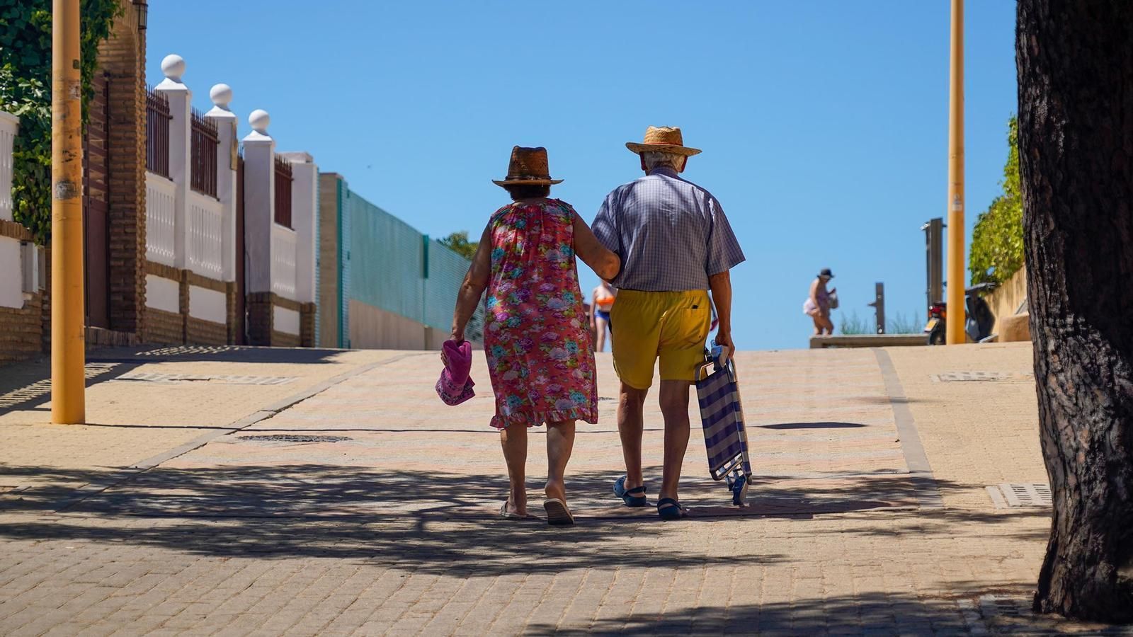 Una pareja se dirige a la playa de Punta Umbría. Una pareja se dirige a la playa de Punta Umbría.