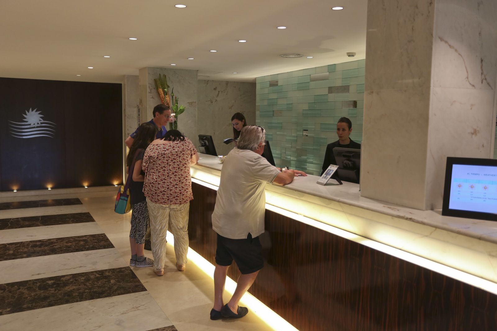 Varios turistas en la recepción de un hotel