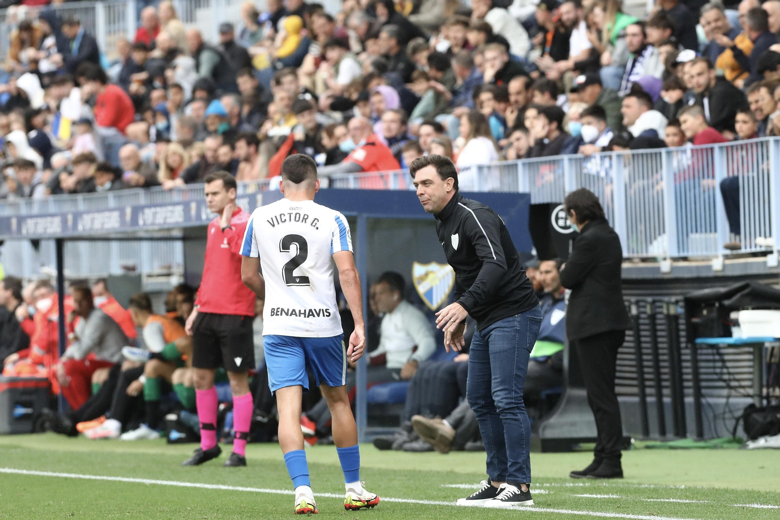 Guede conversa con Víctor Gómez en el Málaga CF-Eibar.