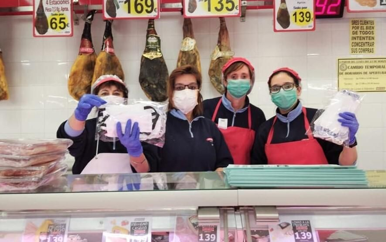 Trabajadoras de un supermercado en Nueva Carteya muestran las mascarillas confeccionadas por voluntarias del municipio.