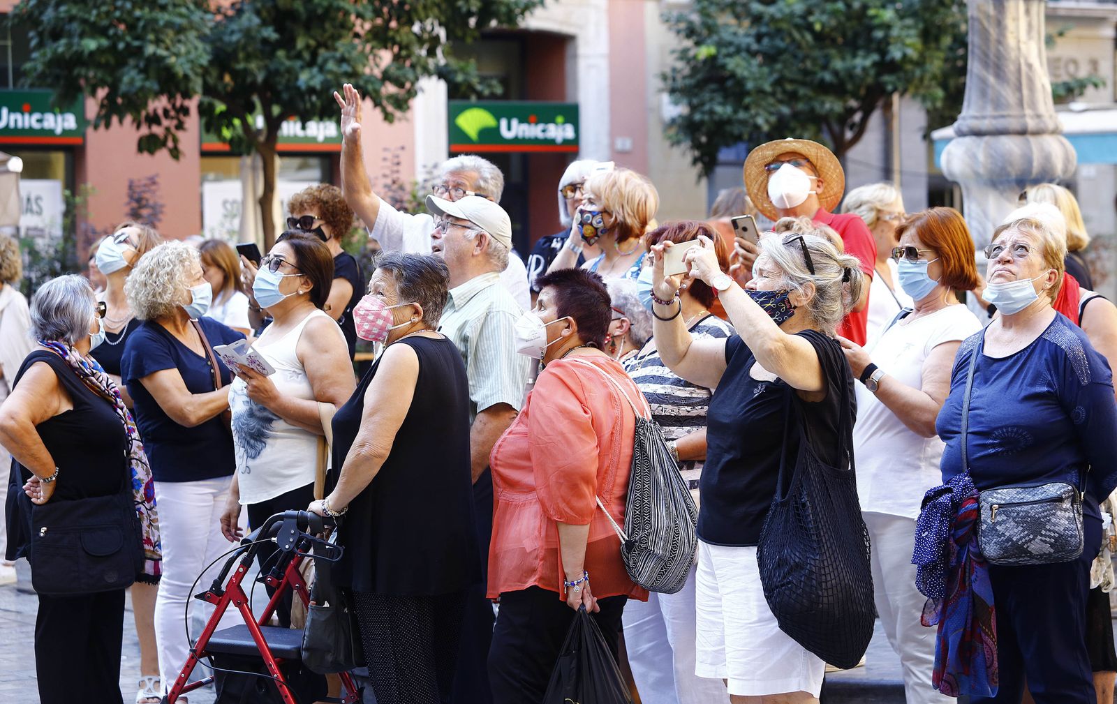 Turistas atienden las explicaciones de un guía en la puerta de la Catedral de Málaga.