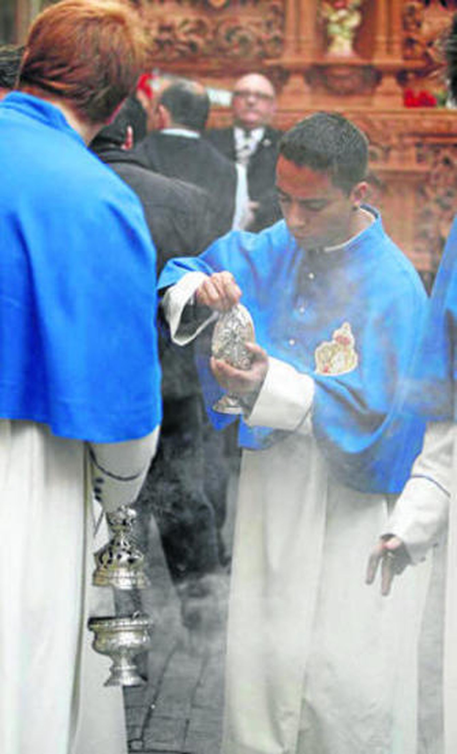 Los acólitos turiferarios rellenan los incensarios.