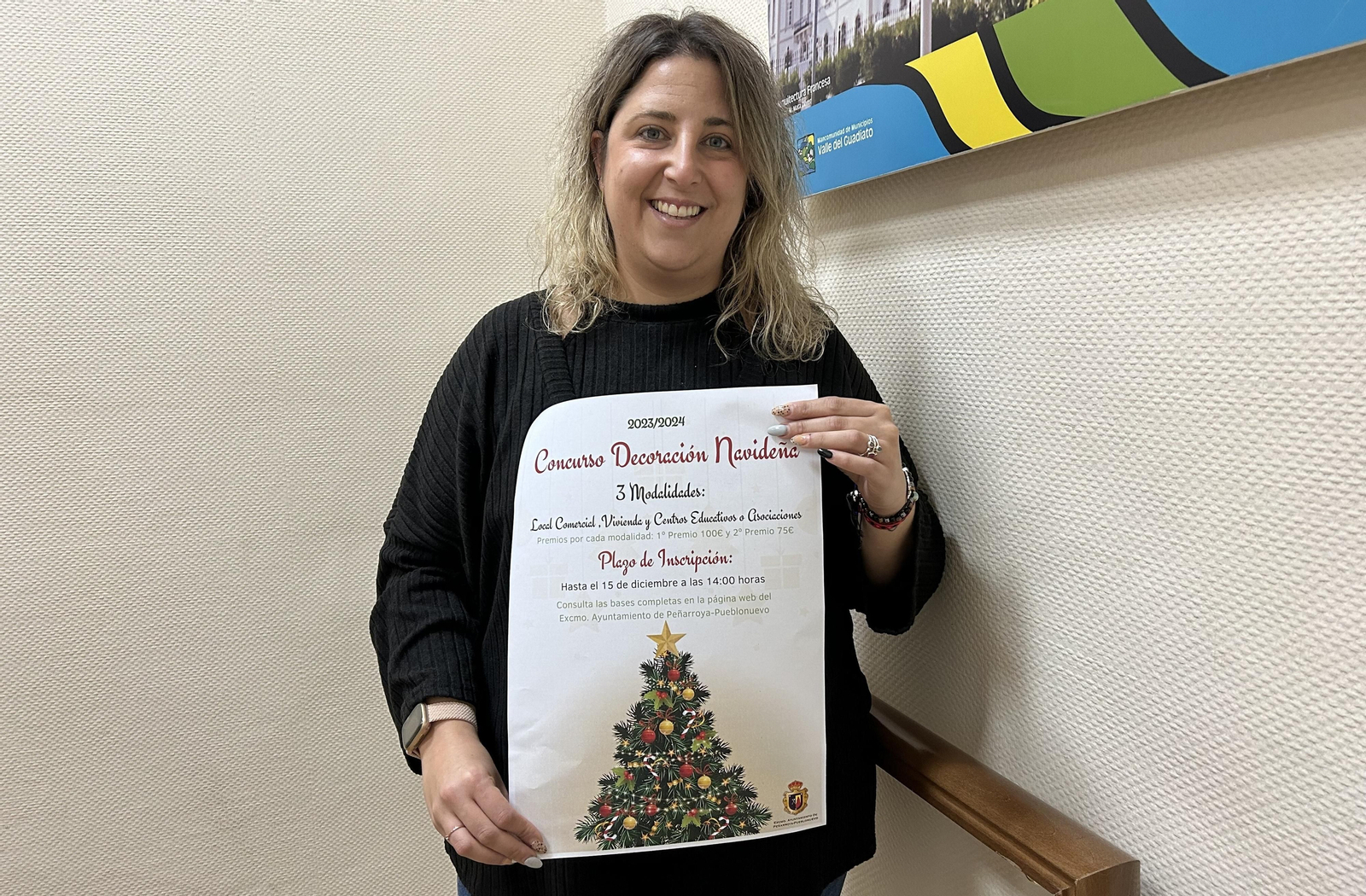 La concejala de Turismo y Comercio, Victoria Muñoz, con el cartel del concurso navideño.