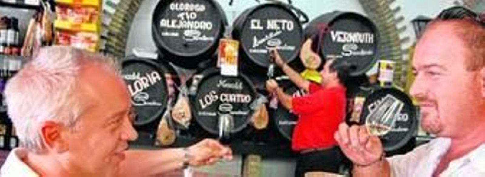 Dos clientes de la bodega degustan una copa de vino.