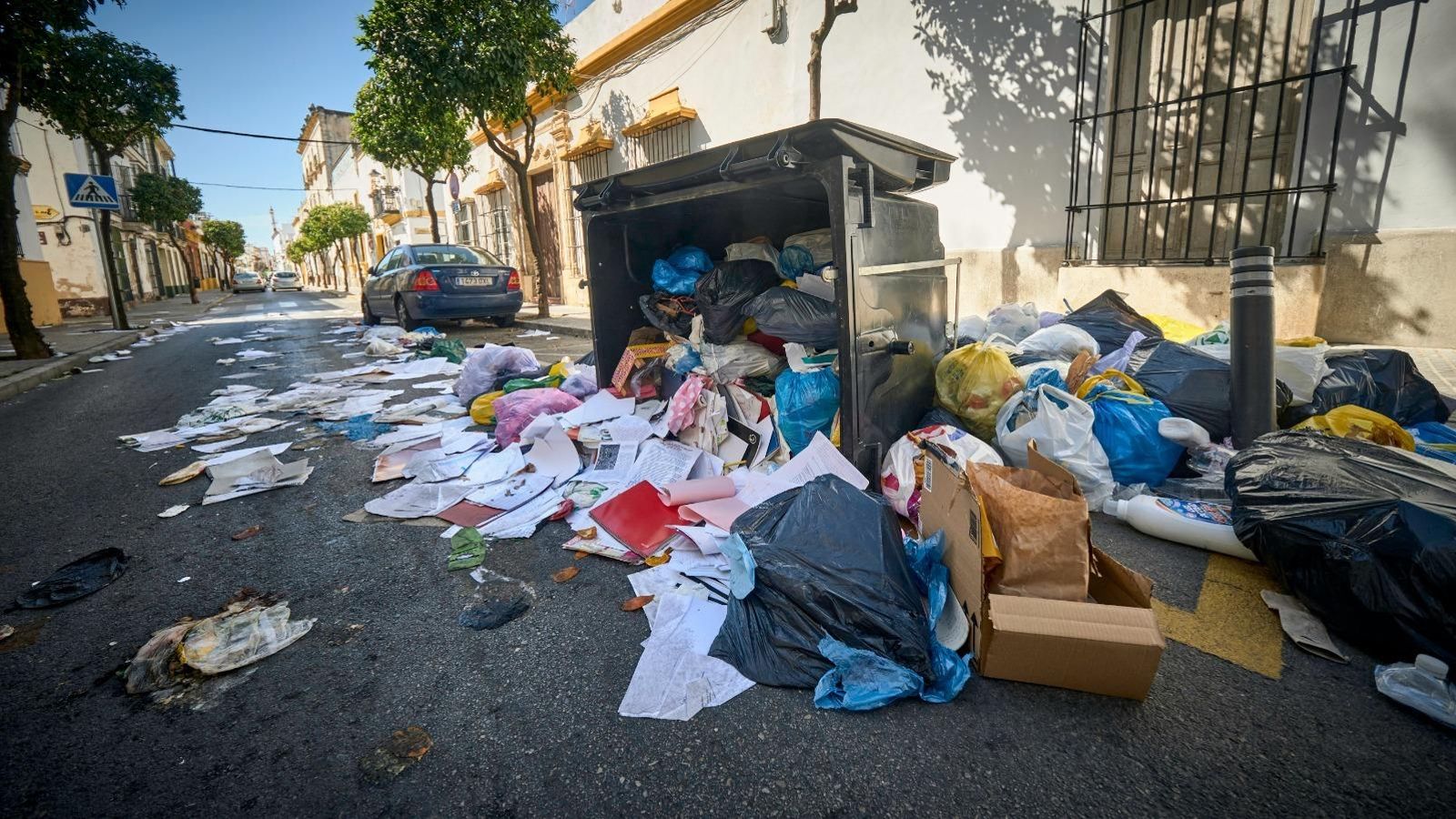 Un contenedor volcado en la calle Cielo, con la basura esparcida por el suelo.