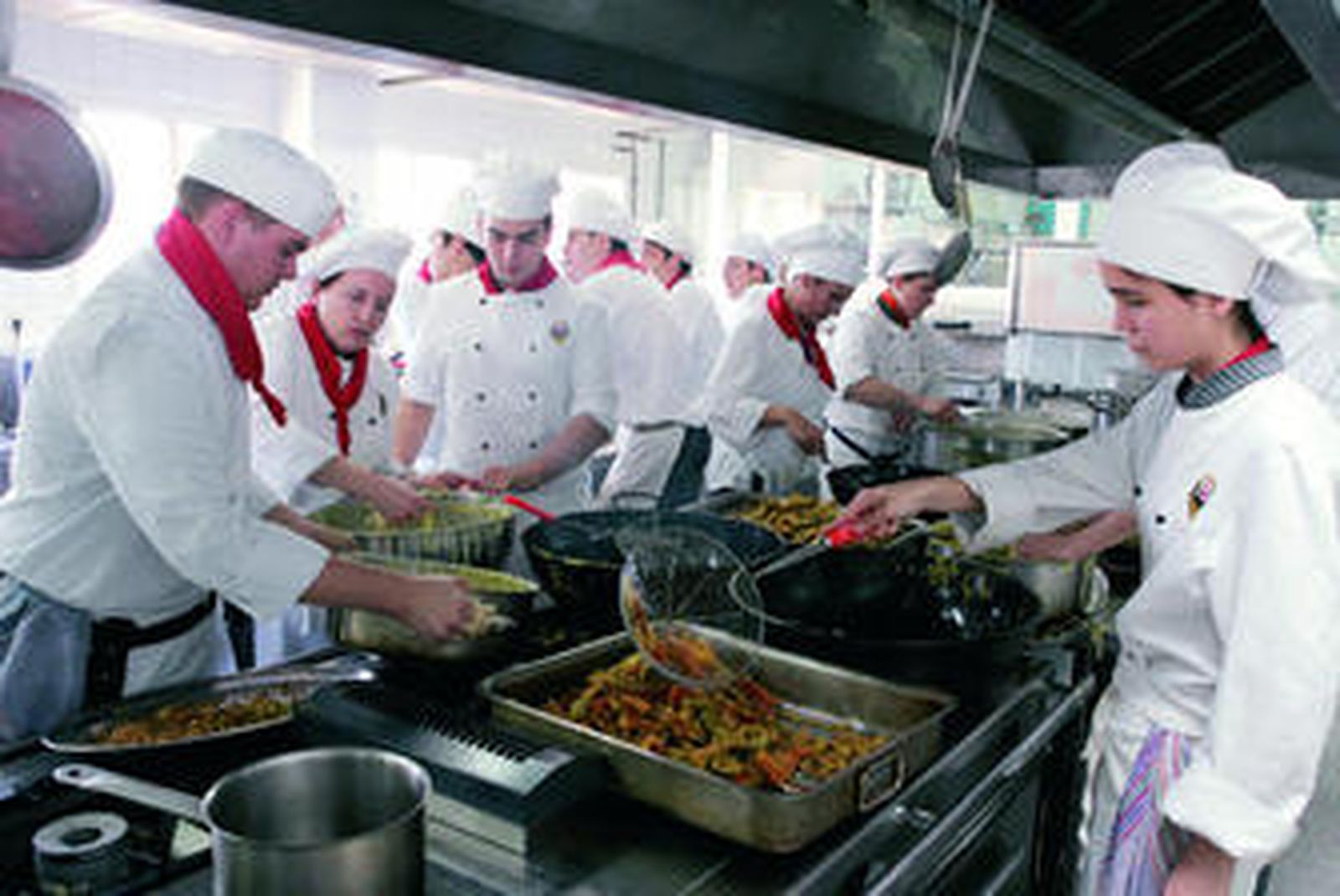 Los cocineros preparan los pimientos en el interior de la cocina.