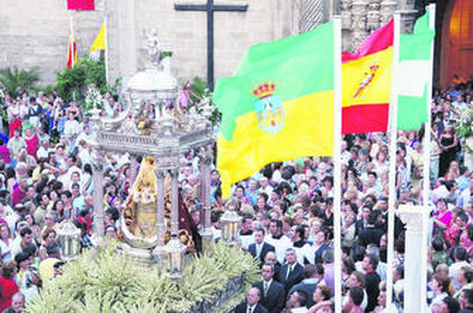 La imagen de Nuestra Señora de los Milagros, ya en la Plaza de España ante las banderas de El Puerto, Andalucía y España.