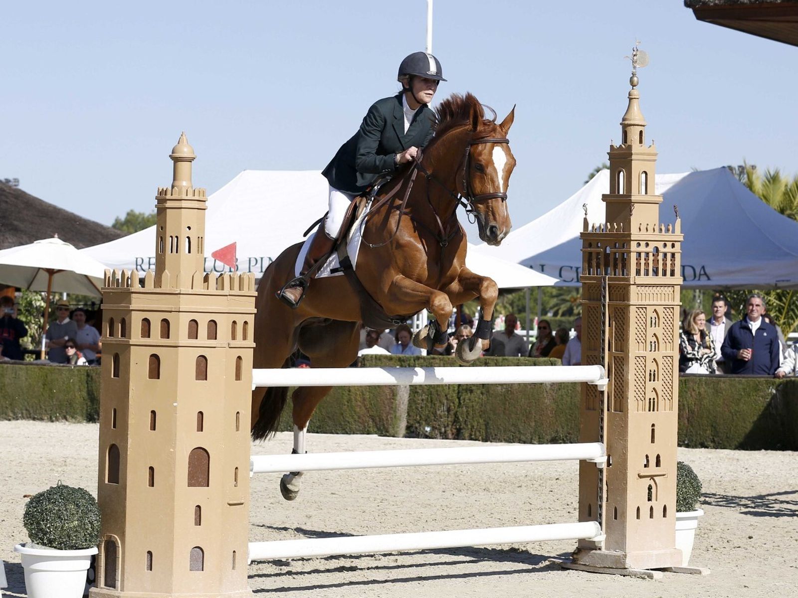 La infanta Elena salta uno de los obstáculos con la Giralda y la Torre del Oro.
