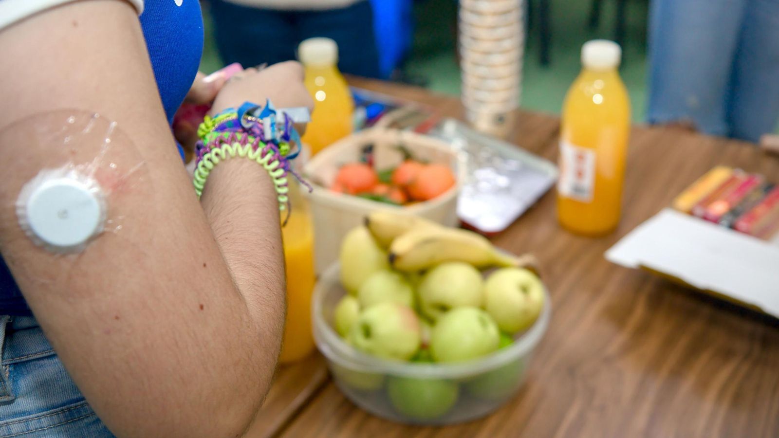 Una chica, con un dispositivo de monitorización de la diabetes.