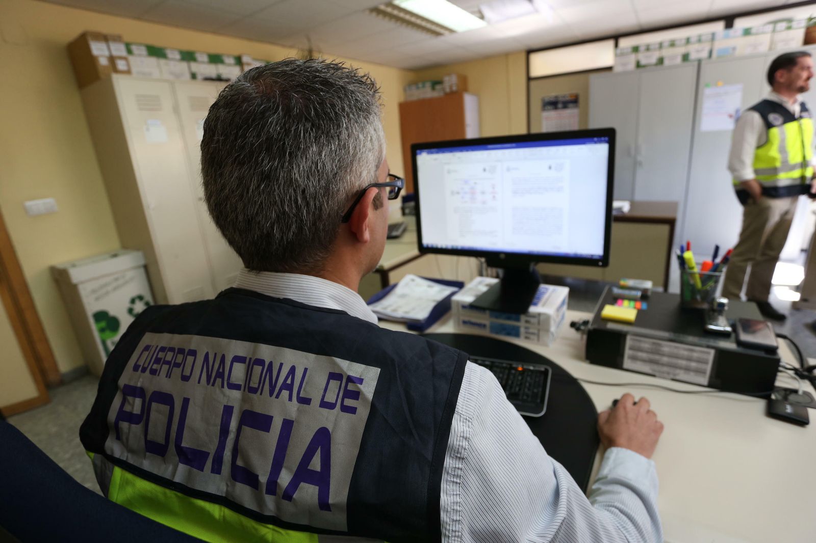 El policía nacional que inició la investigación consulta una documentación en su ordenador.
