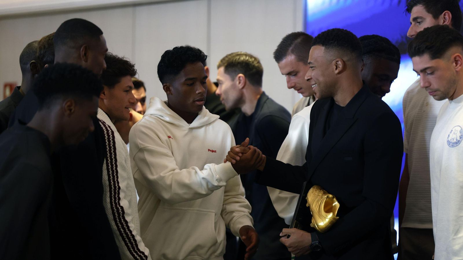Mbappé recibe la felicitación de Rodrygo entre el resto de compañeros del Madrid.