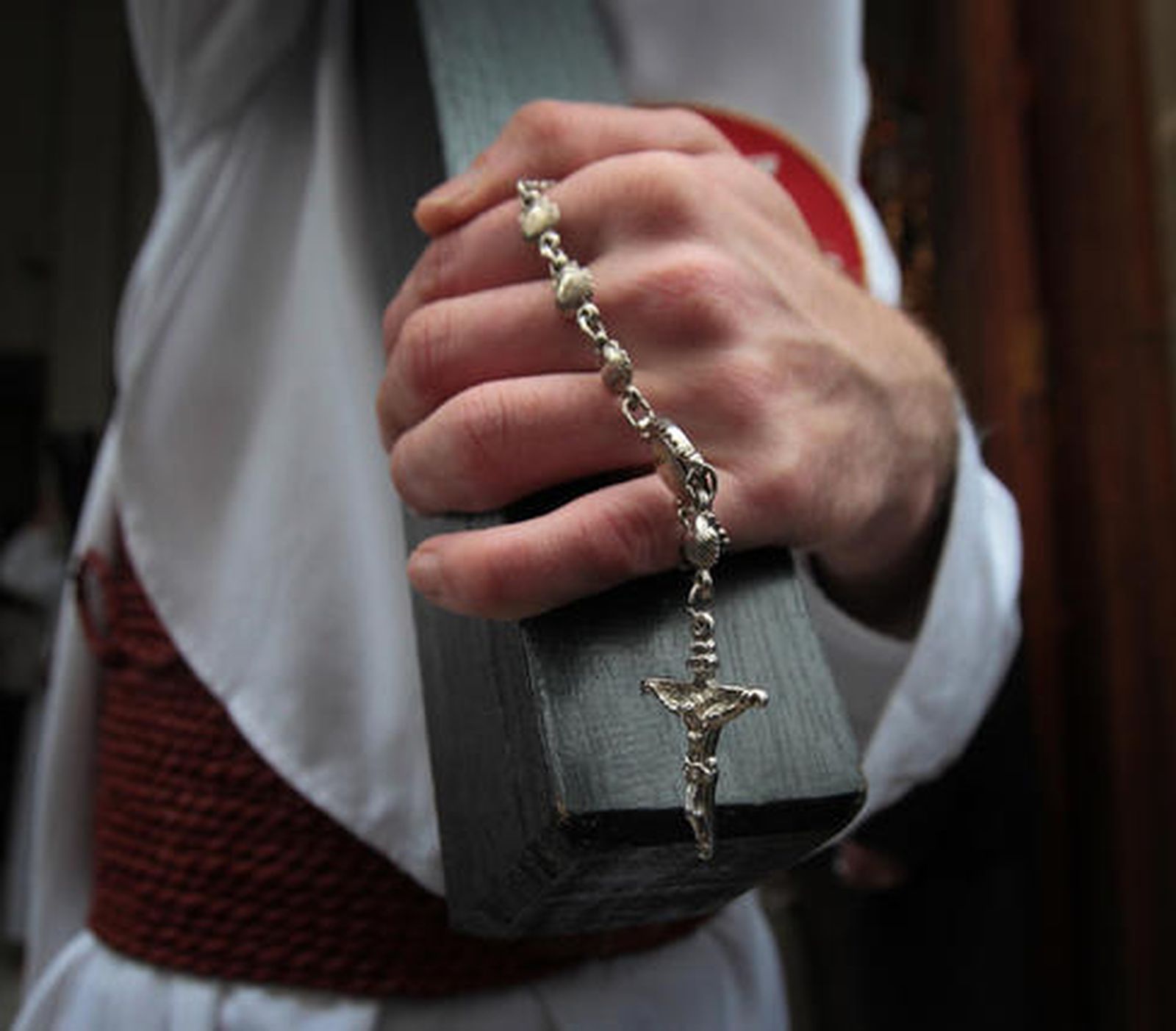 Uno de los nazarenos del Santísimo Cristo del Amor, rosario en mano, hace estación de penitencia con una cruz.

Foto: Miguel Angel Gonzalez