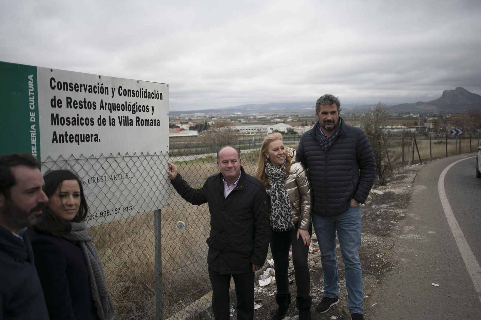 Representación del PP junto al cartel de la Junta que anuncia una actuación en pesetas.